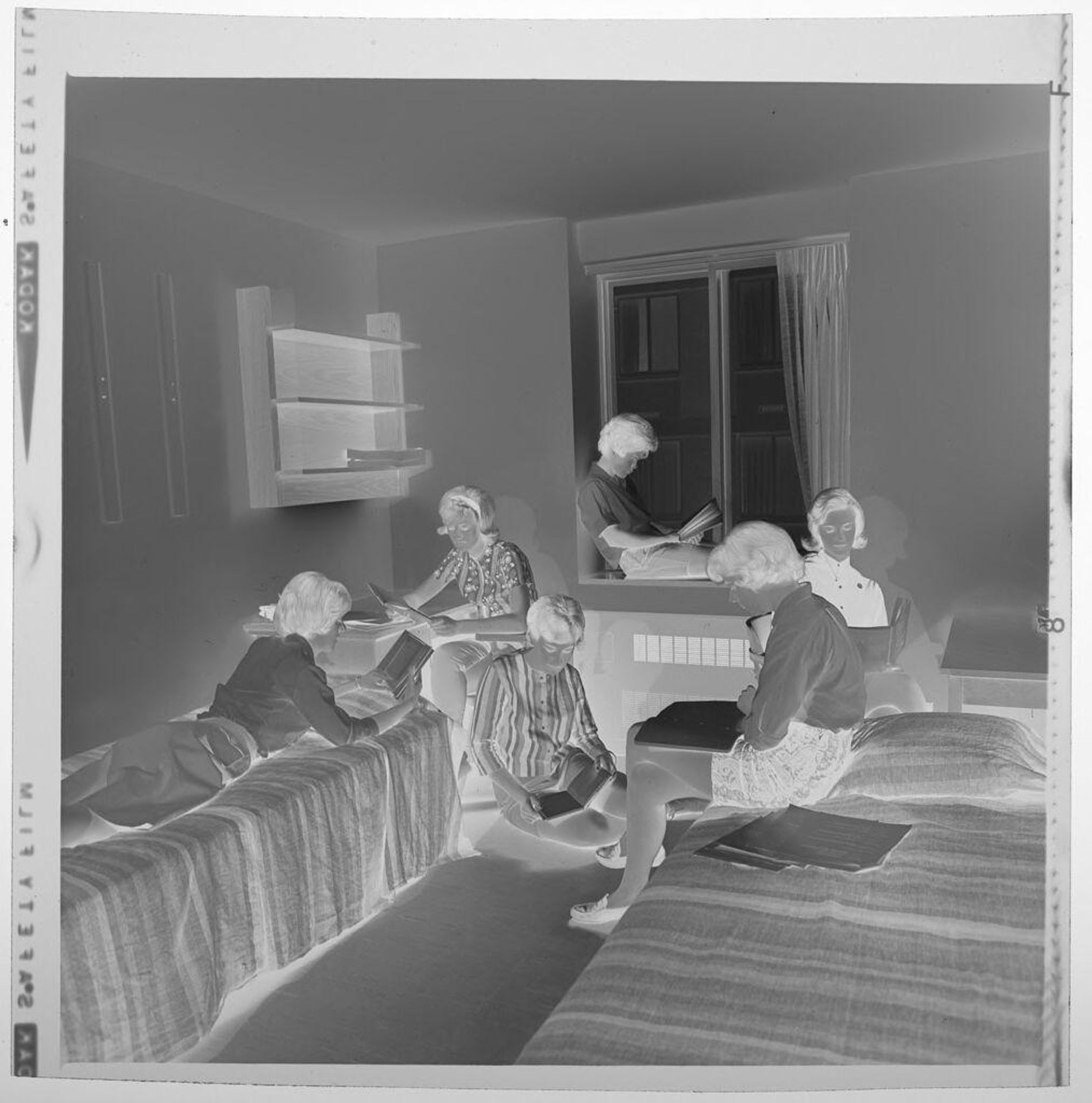 Untitled (young people studying on beds and at desk in room) by Jack Gould