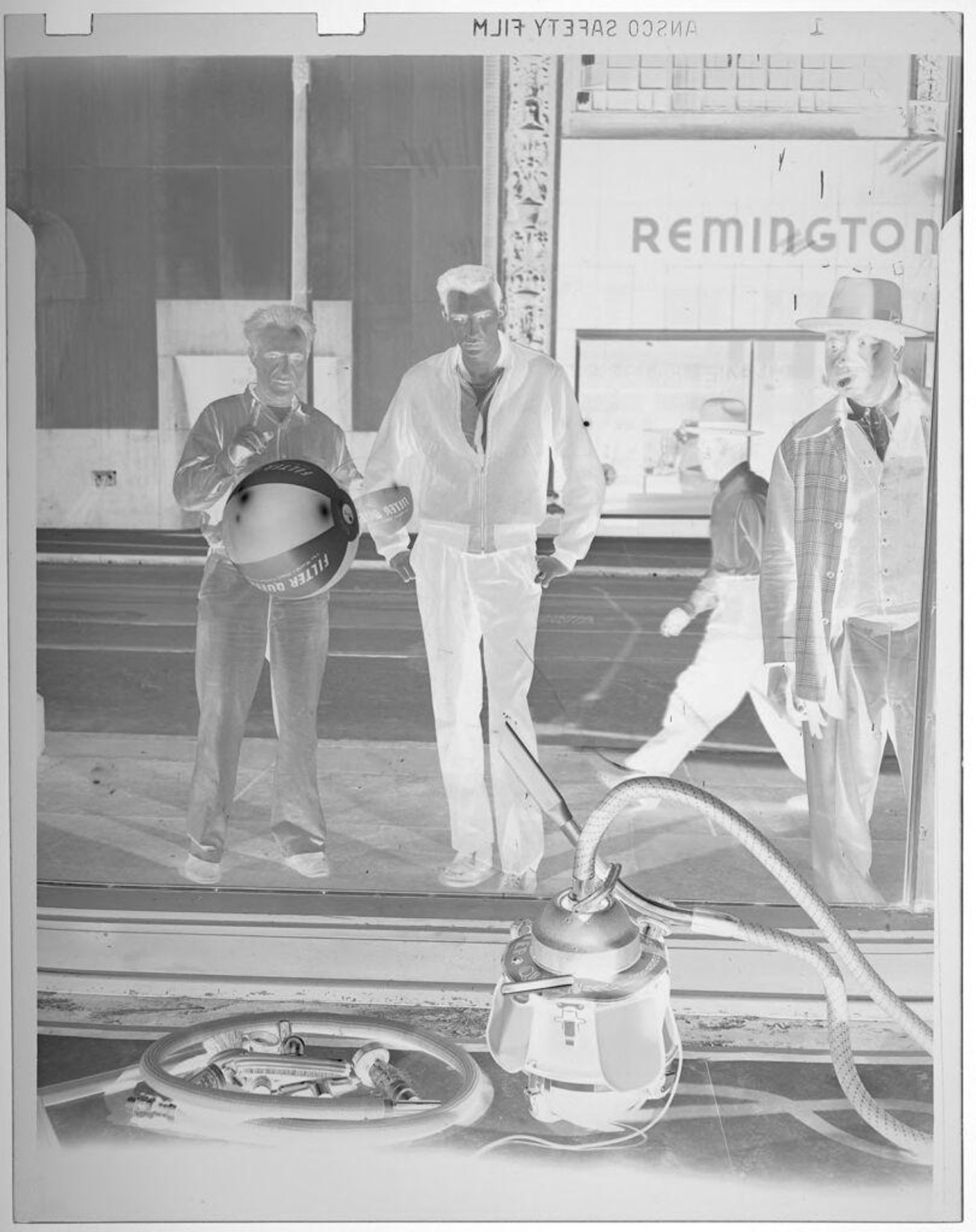 Untitled (men looking into store window displaying vacuum contraption) by Jack Gould