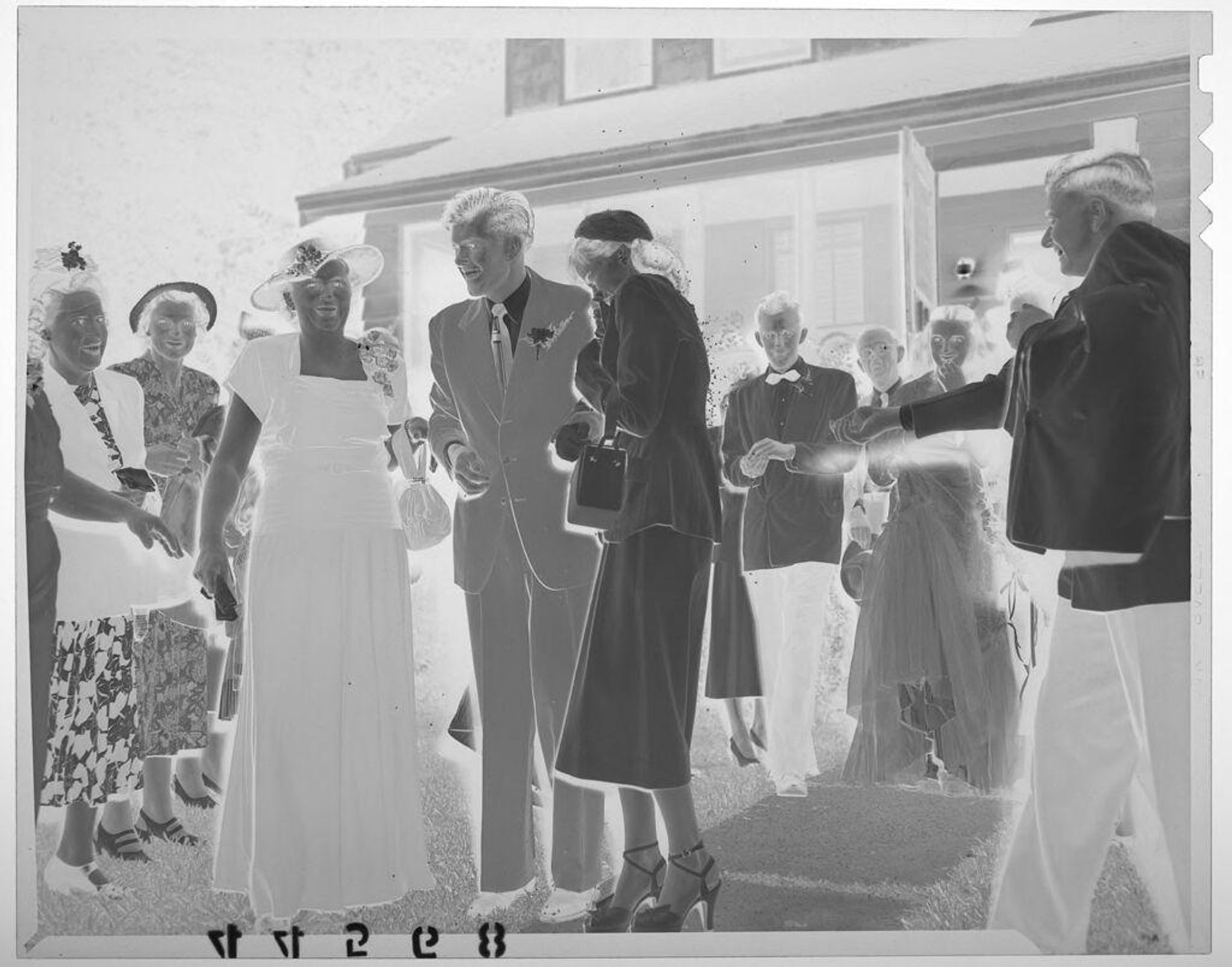 Untitled (group of people throwing rice on newlywed couple standing next to older woman) by Martin Schweig