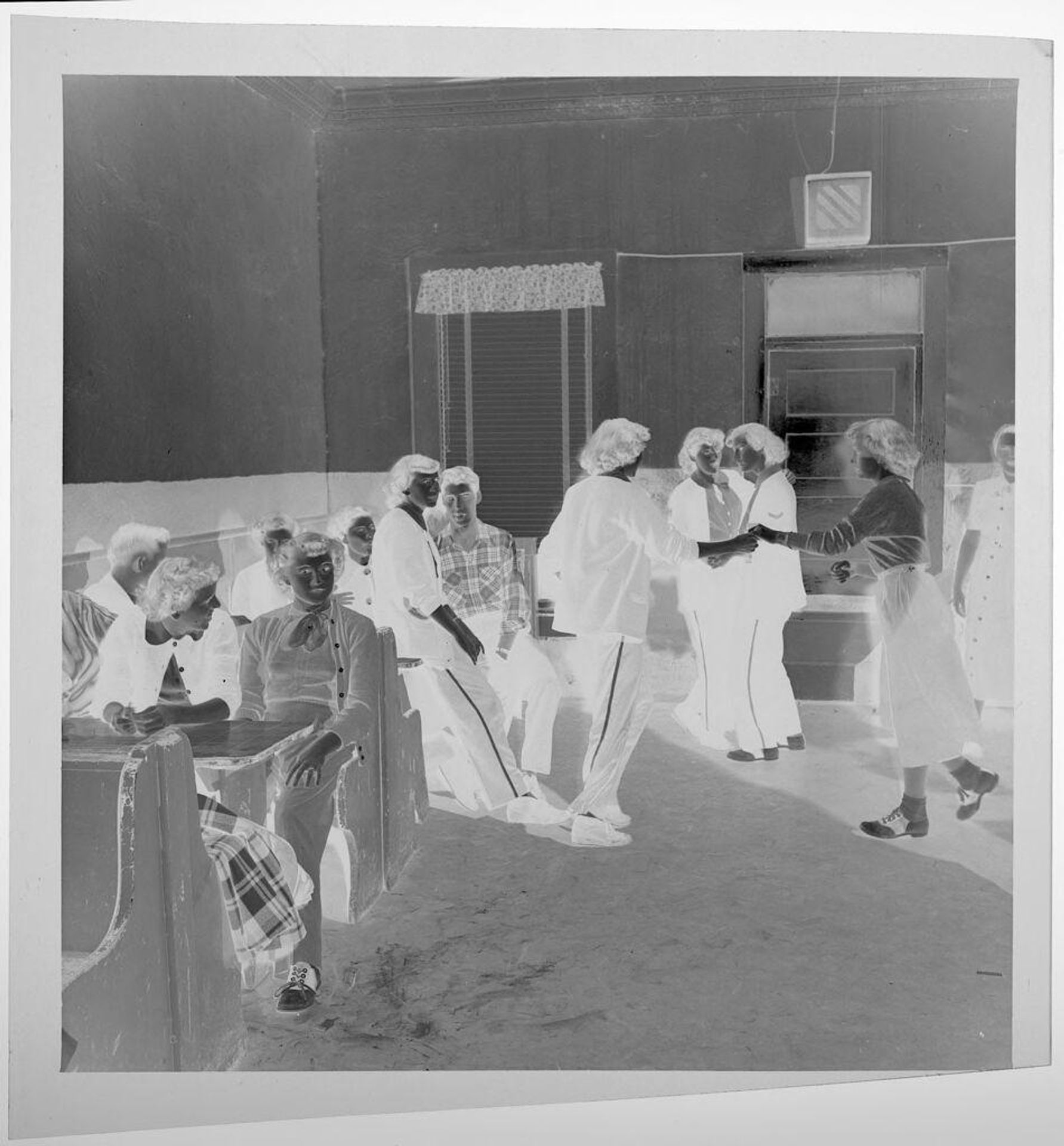 Untitled (people sitting at booths in pub, two women dancing together) by Jack Gould