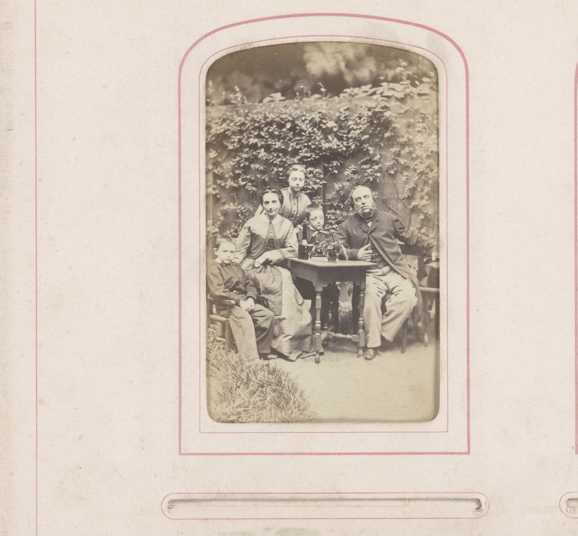 Groepsportret van Bastiaan de Greef met vrouw en drie kinderen rond een tafel in tuin by Leonard de Koningh