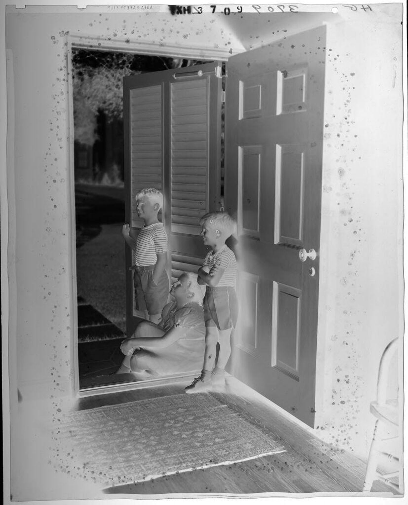 Untitled (three siblings posed in doorway to house) by Paul Gittings