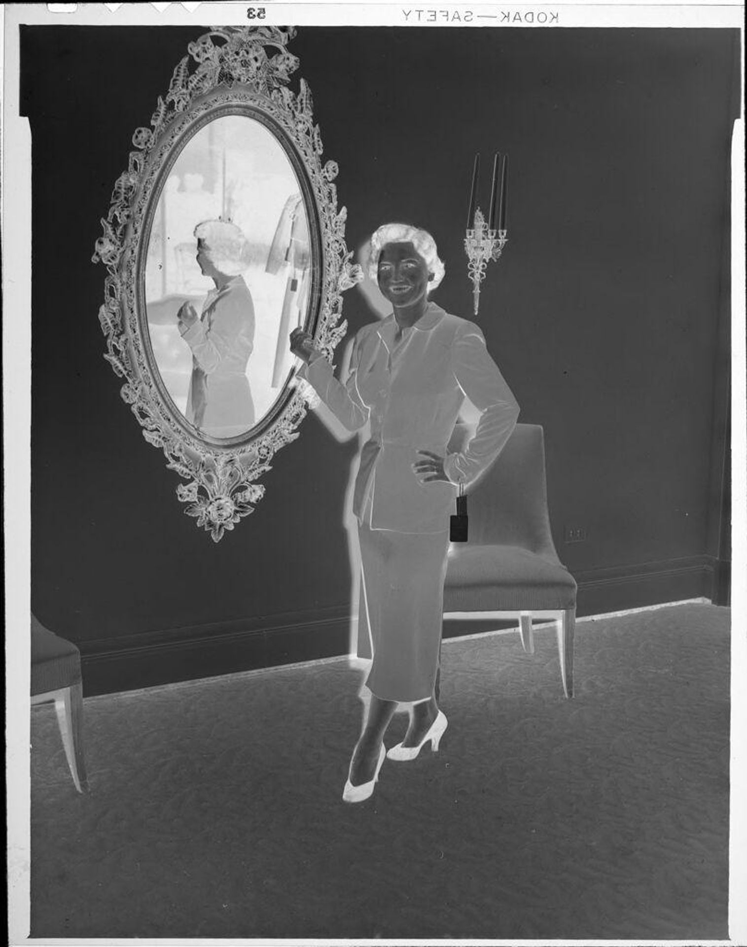 Untitled (woman standing in front of large mirror) by Robert Burian