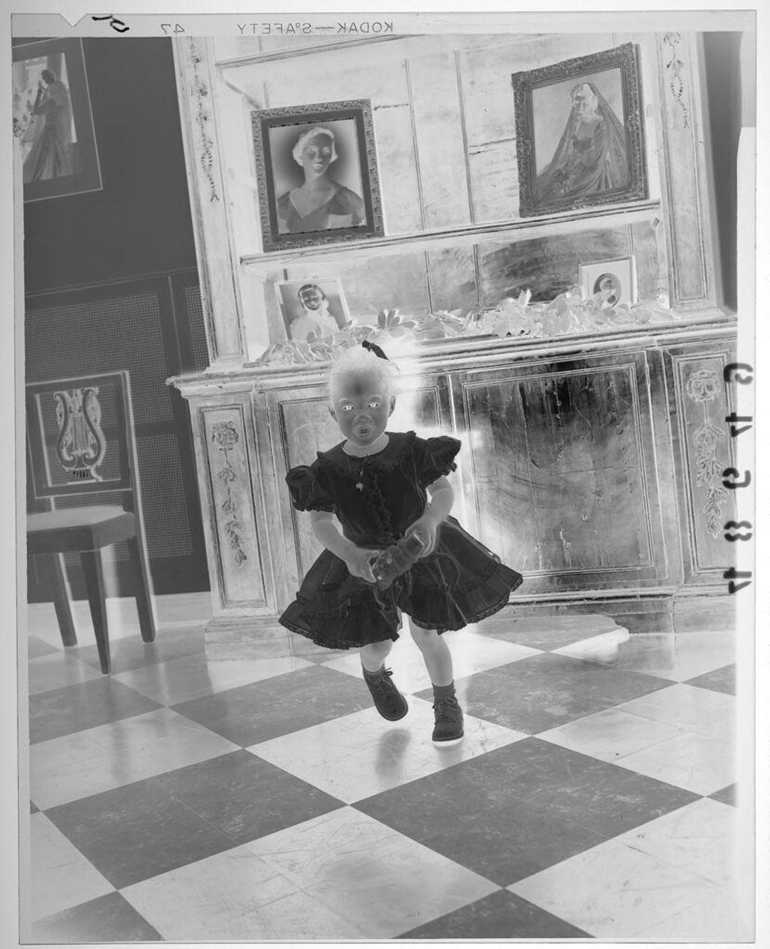 Untitled (young girl posed standing in fancy room with white bride portraits on wall) by Martin Schweig