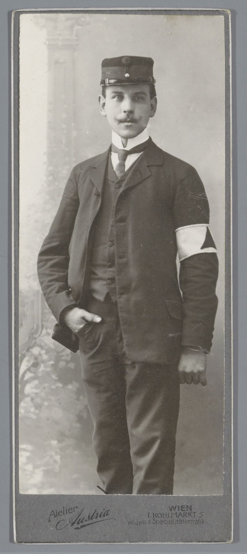 Portret van een onbekende man met pet en band om arm by Strauss & Co.