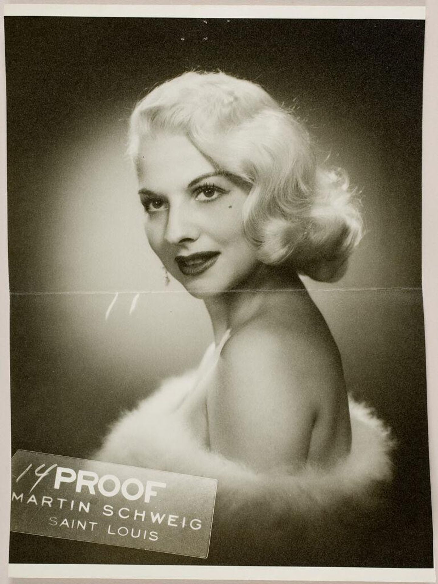 Untitled (studio portrait of blond woman wearing white fur around her shoulders) by Martin Schweig
