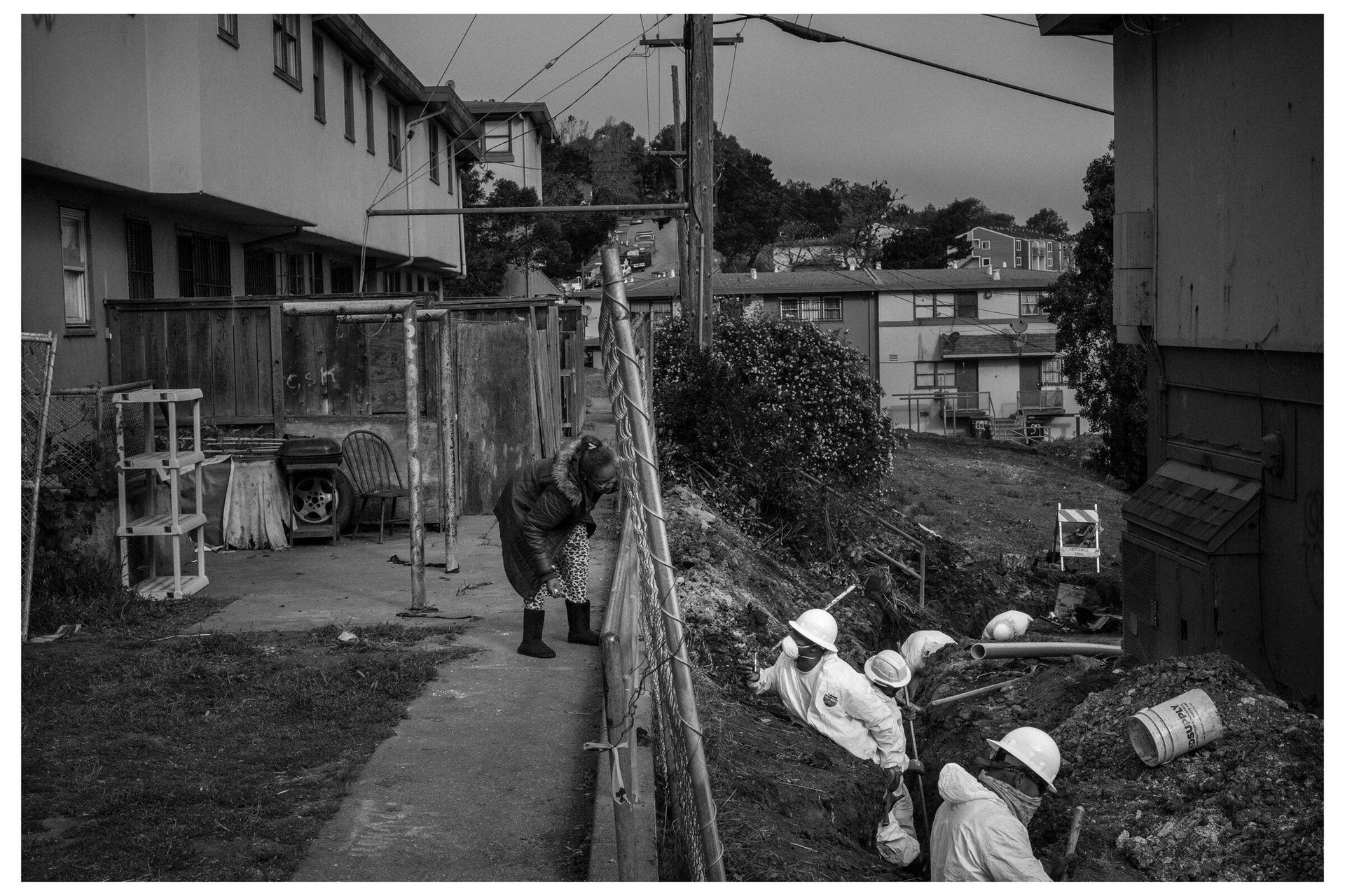 A resident talks to workers in the Hunters Point neighborhood of San Francisco, California on May 5, 2017. by Ashley Gilbertson