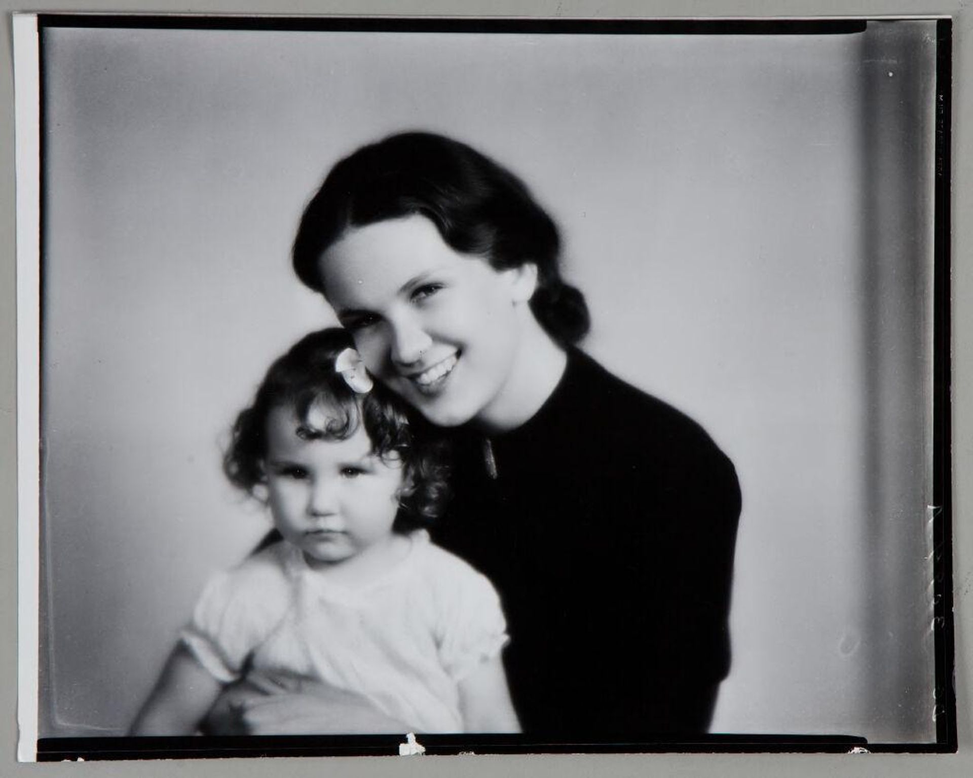 Untitled (smiling woman holding young girl on her lap) by Paul Gittings