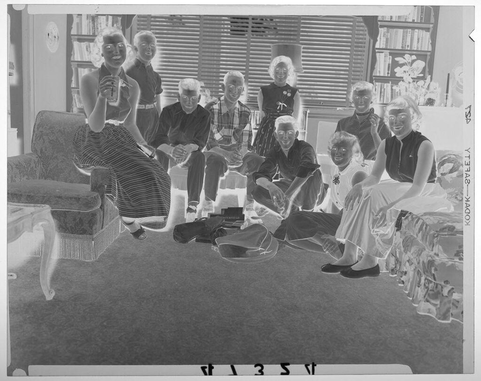 Untitled (nine children posed sitting in living room with presents on the floor) by Martin Schweig