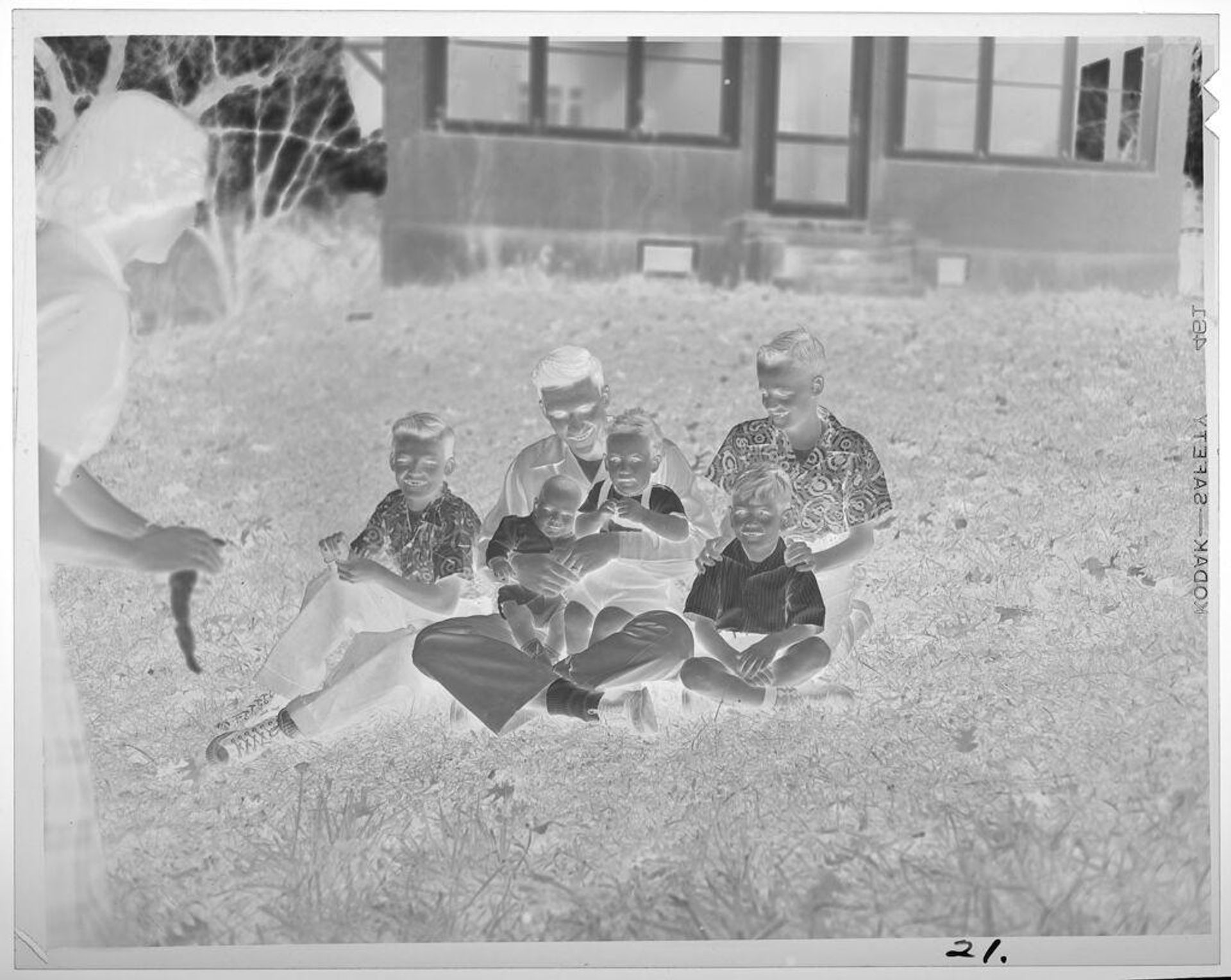 Untitled (young man and kids sitting on ground, woman standing) by Lucian and Mary Brown