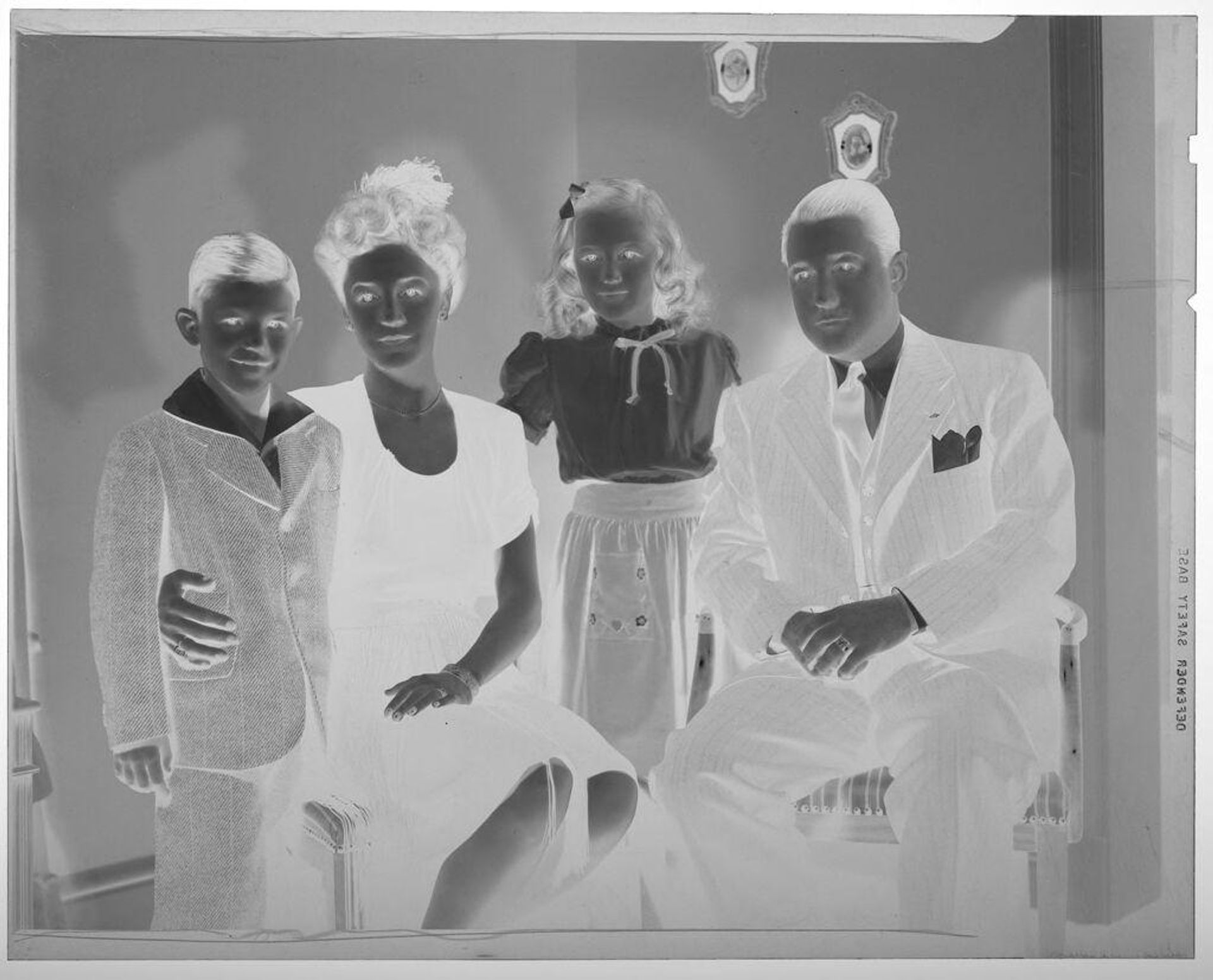 Untitled (parents posed seated with young girl and boy standing in corner of room) by Martin Schweig