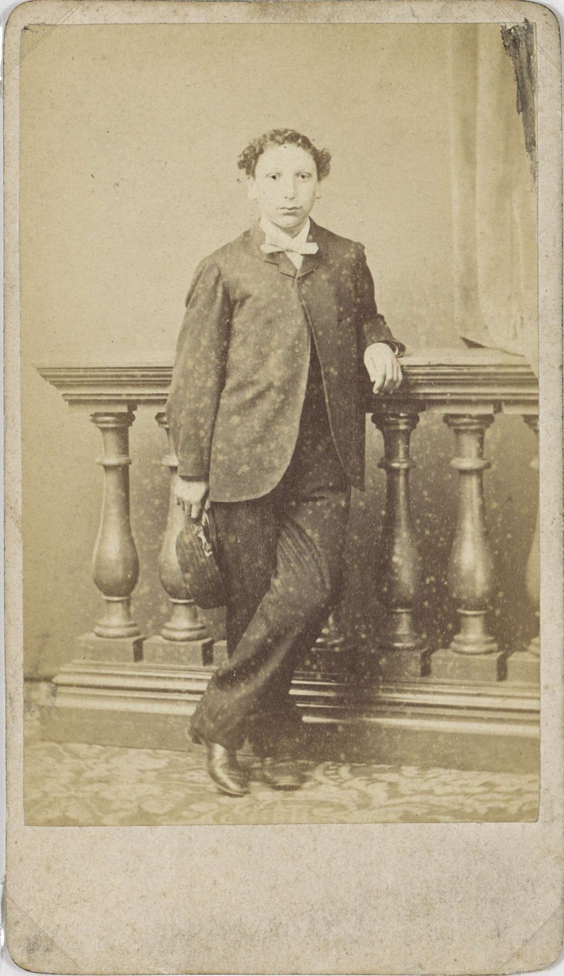 Portret van een staande jongeman met een pet in de hand by Gebroeders Delboy
