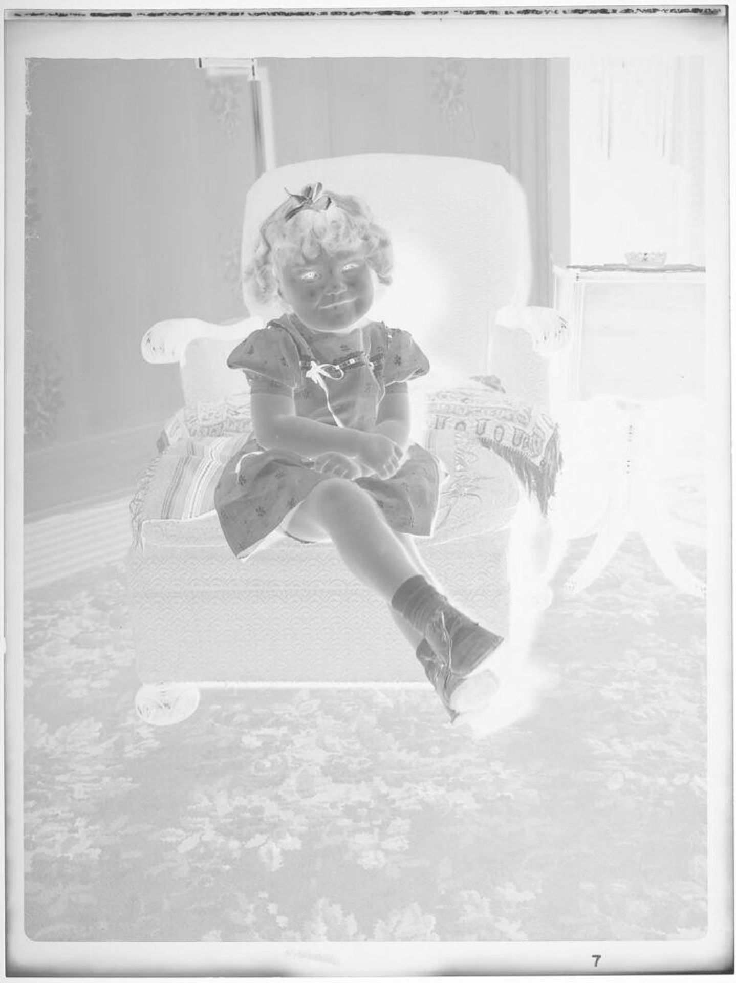 Untitled (little girl seated on armchair) by John Deusing