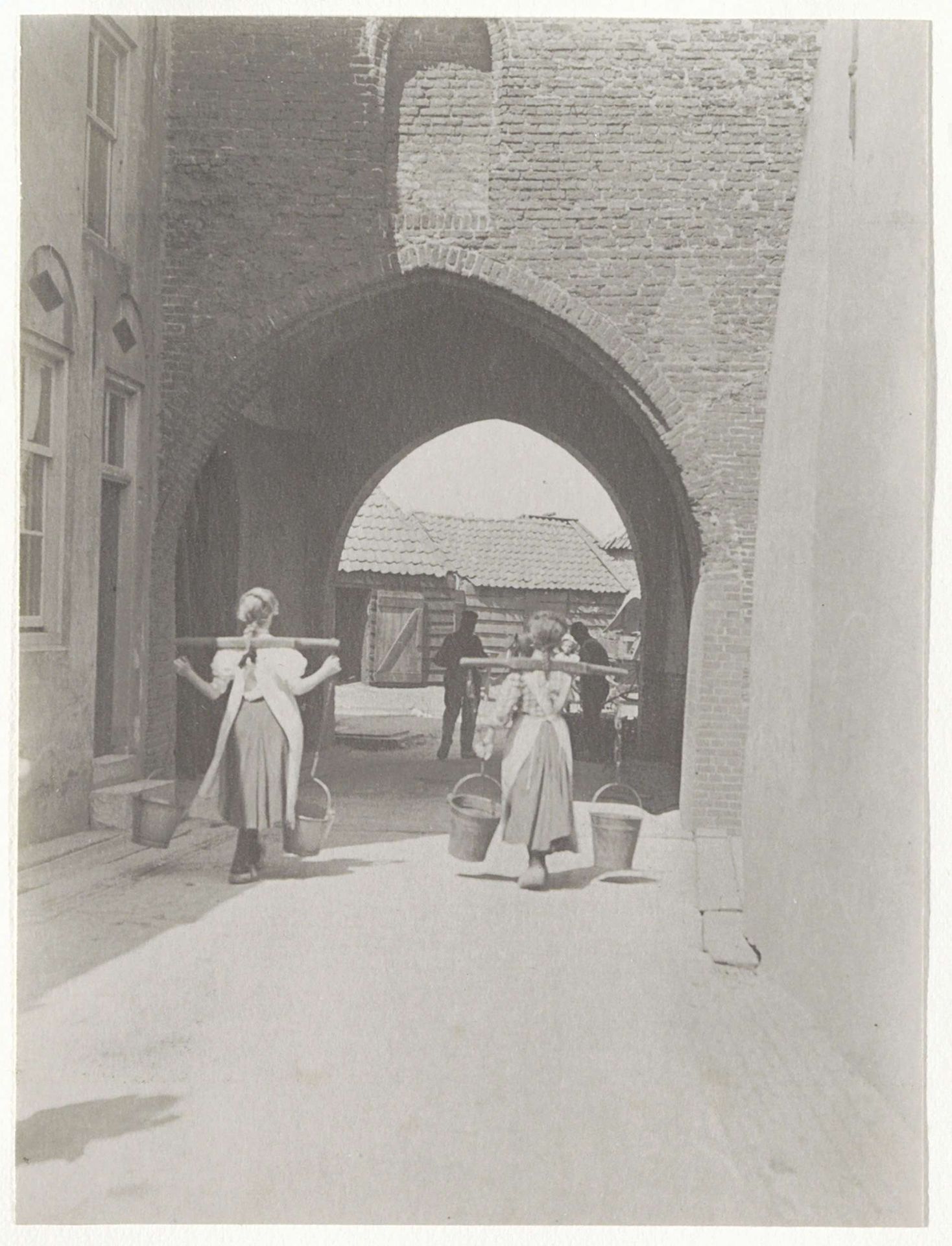 Meisjes met draagjukken bij de Gevangenpoort te Woudrichem by G. Hidderley