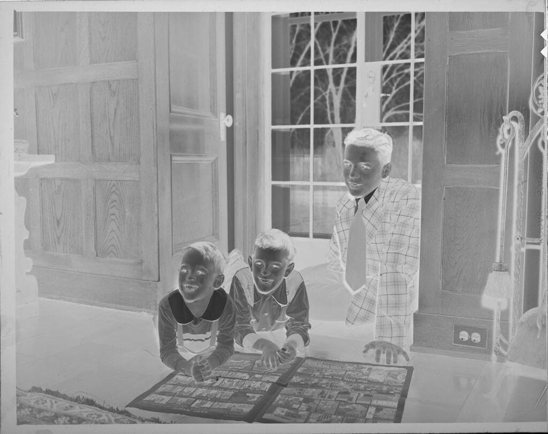 Untitled (three boys on floor reading comics) by Lucian and Mary Brown