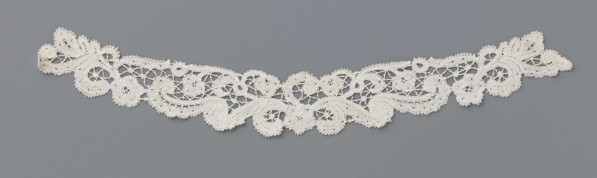 Guimpe van kloskant met symmetrisch voluten patroon by Leon Sacré