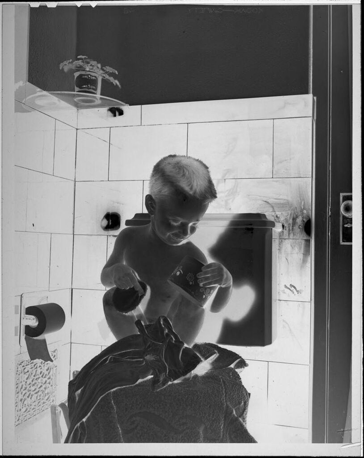 Untitled (boy sitting on toilet) by Lucian and Mary Brown