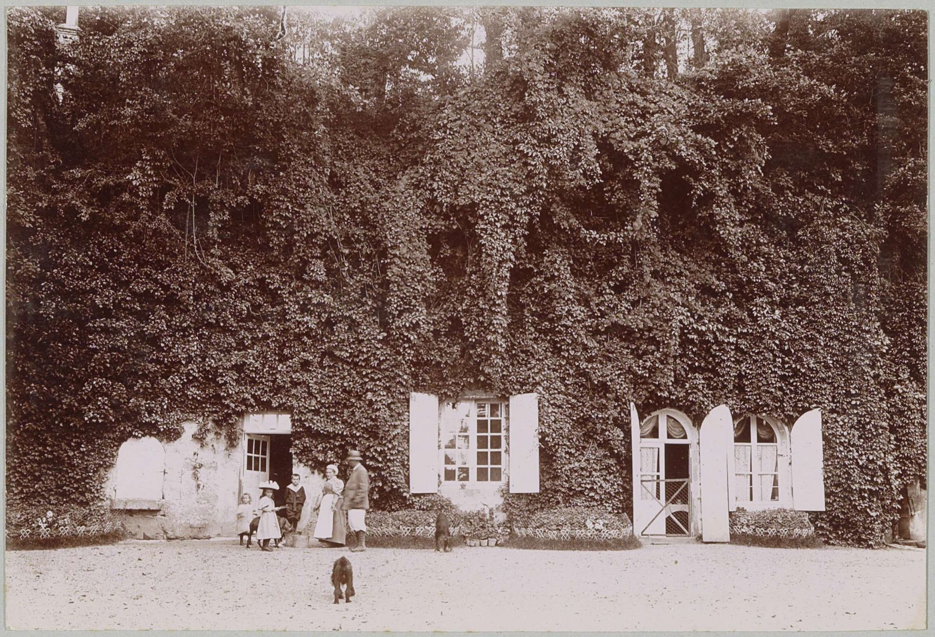 Gezelschap op een binnenplaats (aangeduid als 'La Charpenterie'), vermoedelijk bij een landhuis of kasteel in Frankrijk by Delizy