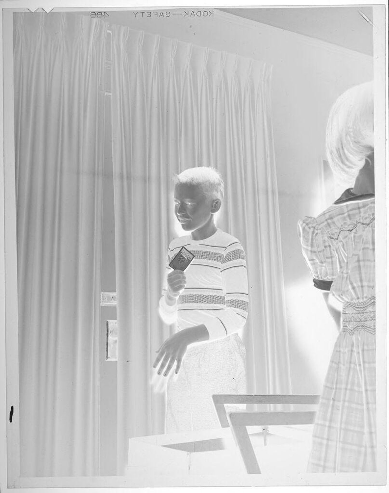 Untitled (boy in striped sweater holding card) by Lucian and Mary Brown