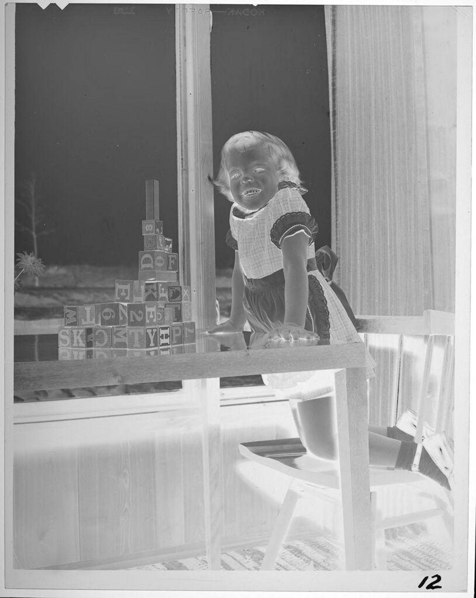 Untitled (girl with alphabet blocks on table) by Lucian and Mary Brown