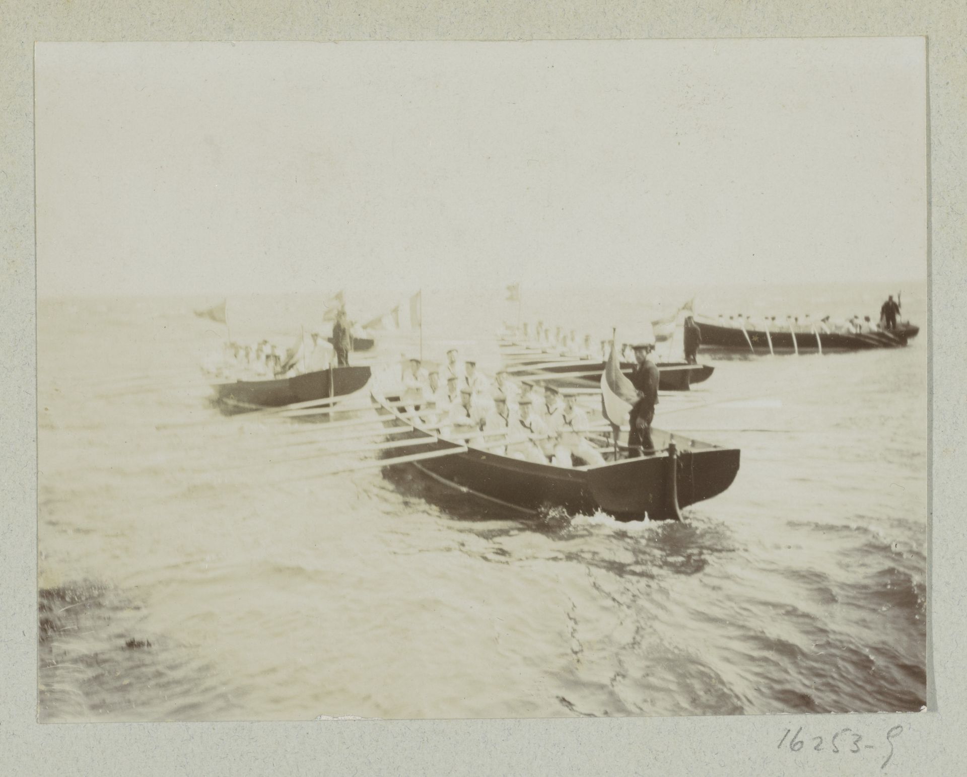 Matrozen roeien in roeiboten op zee by Anonymous