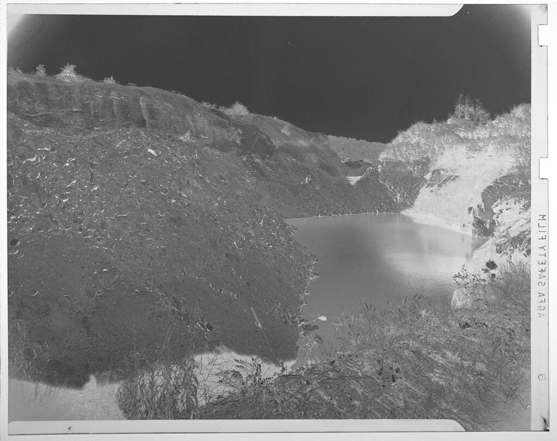 Untitled (reservoir or lake surrounded by rocky hills/cliffs) by Jack Gould