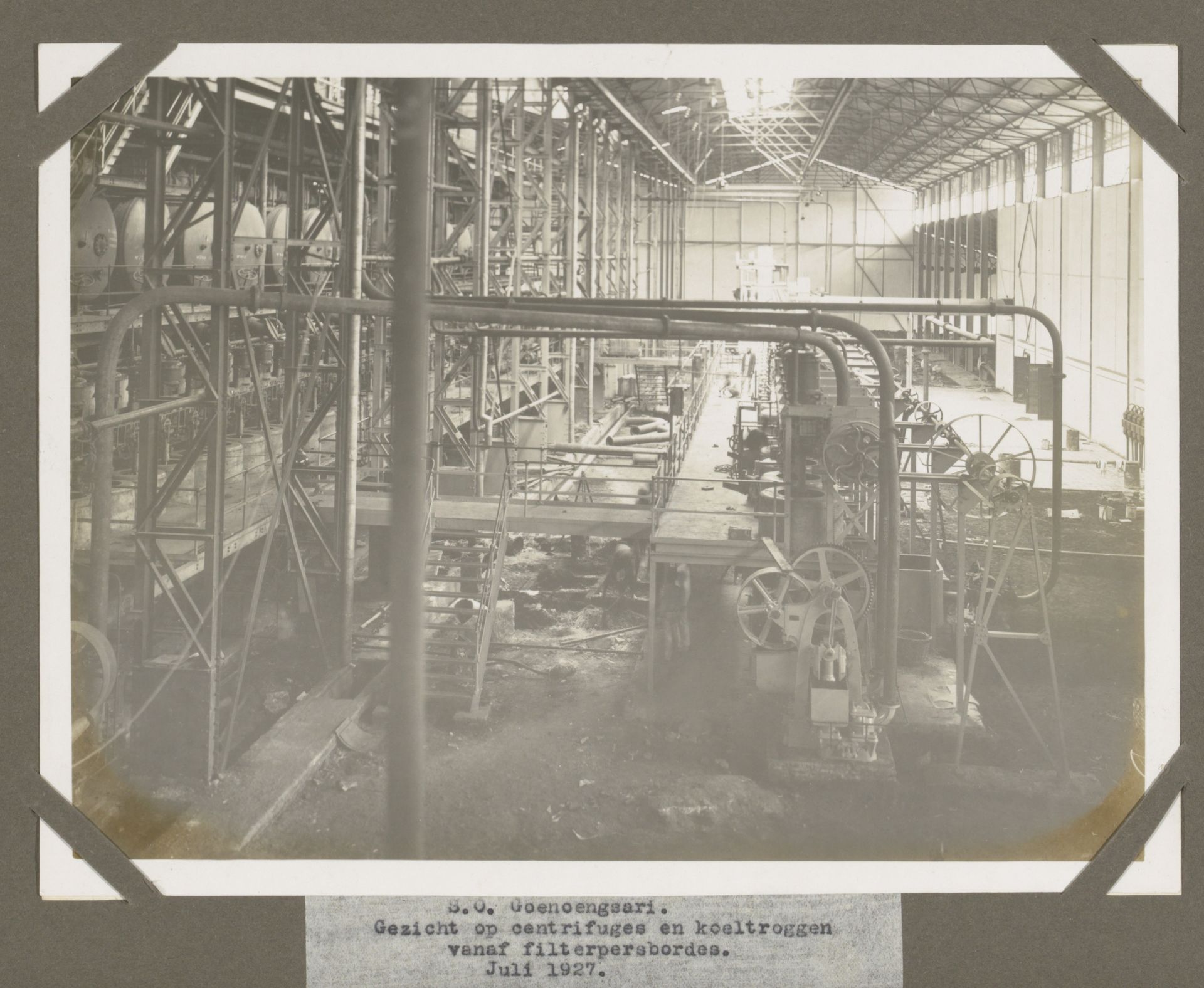 S.O. Goenoengsari. Gezicht op centrifuges en koeltroggen vanaf filterpersbordes. Juli 1927. by Anonymous