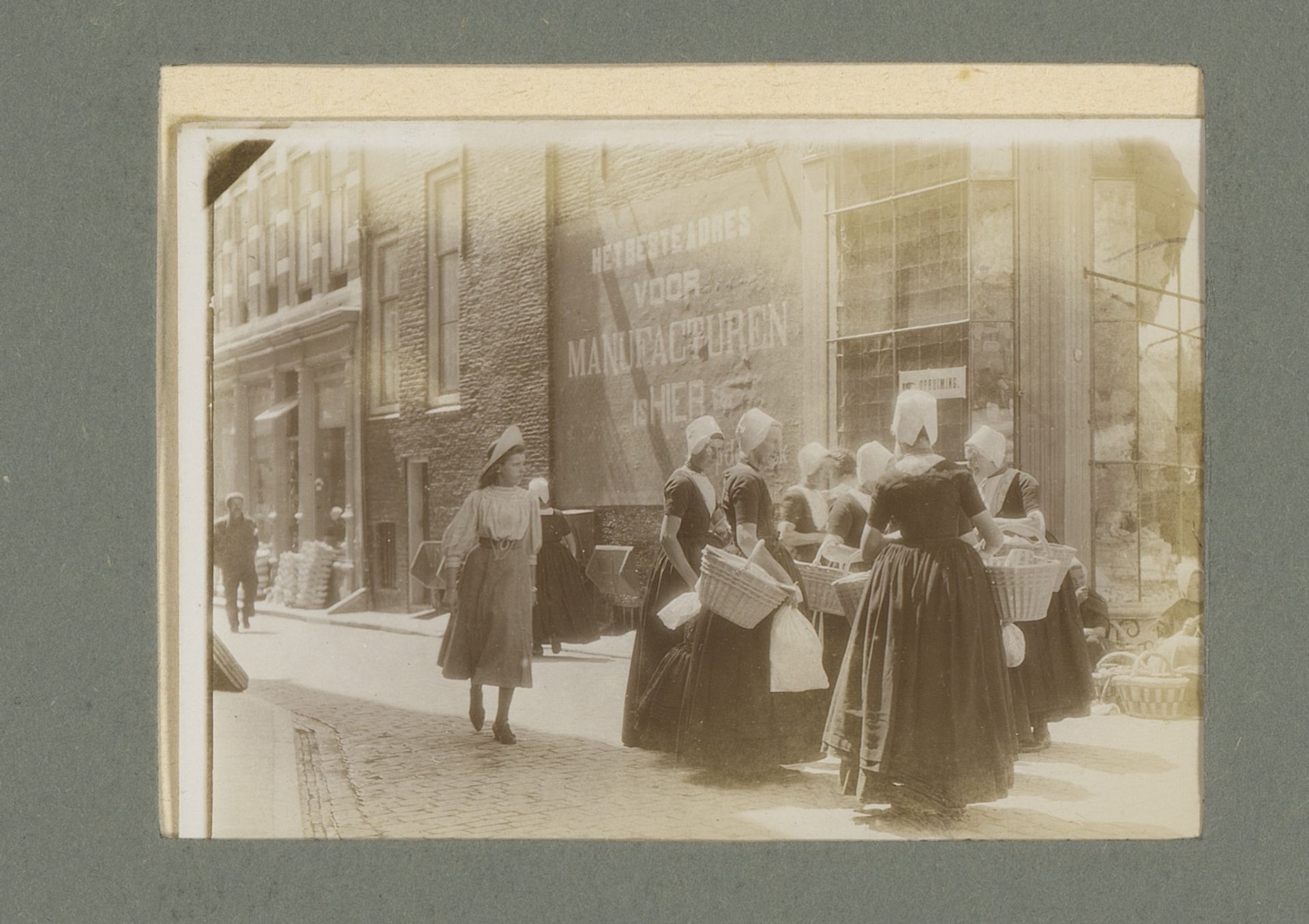 Vrouwen in klederdracht met manden op straat by G. Hidderley