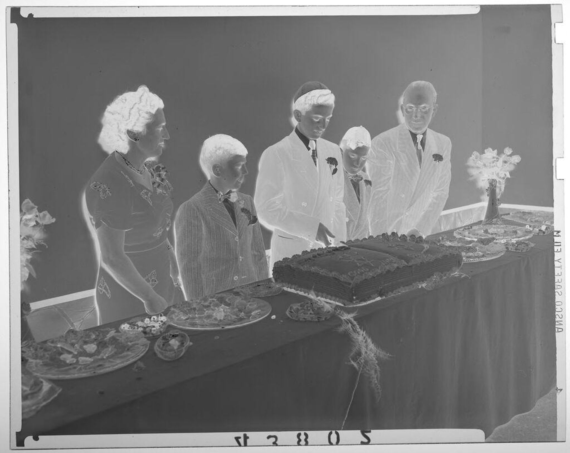 Untitled (boy cutting his Bar Mitzvah cake as his parents and brothers watch) by Martin Schweig
