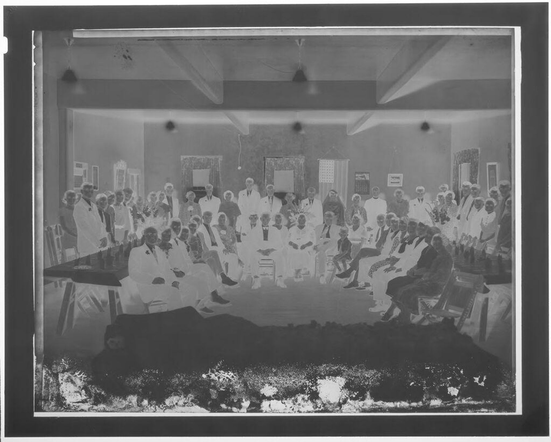 Untitled (gathering of adults seated and standing around room) by John Deusing