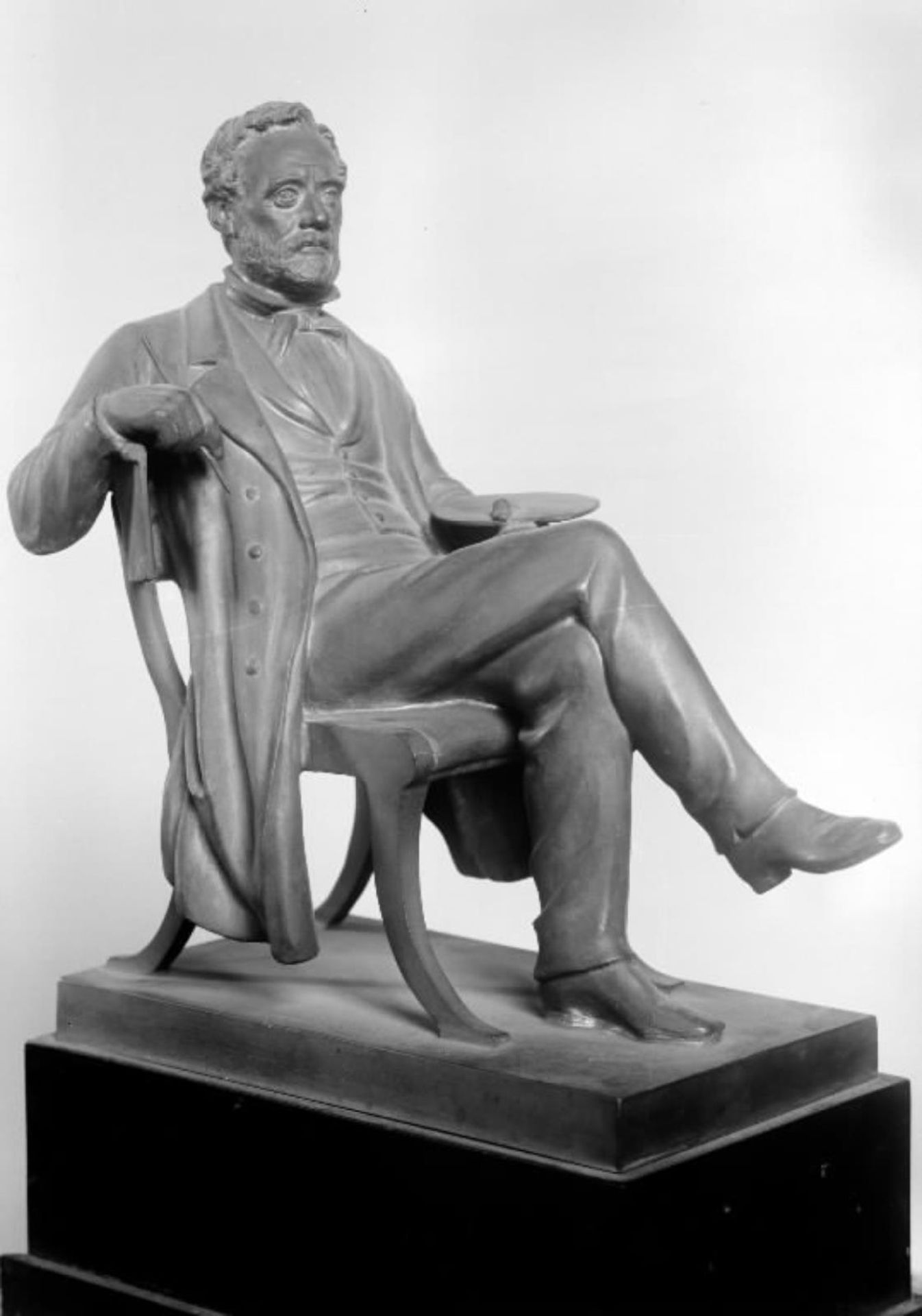 Maleren Wilhelm Marstrand siddende med en pensel og palet i en stol by O. Evens