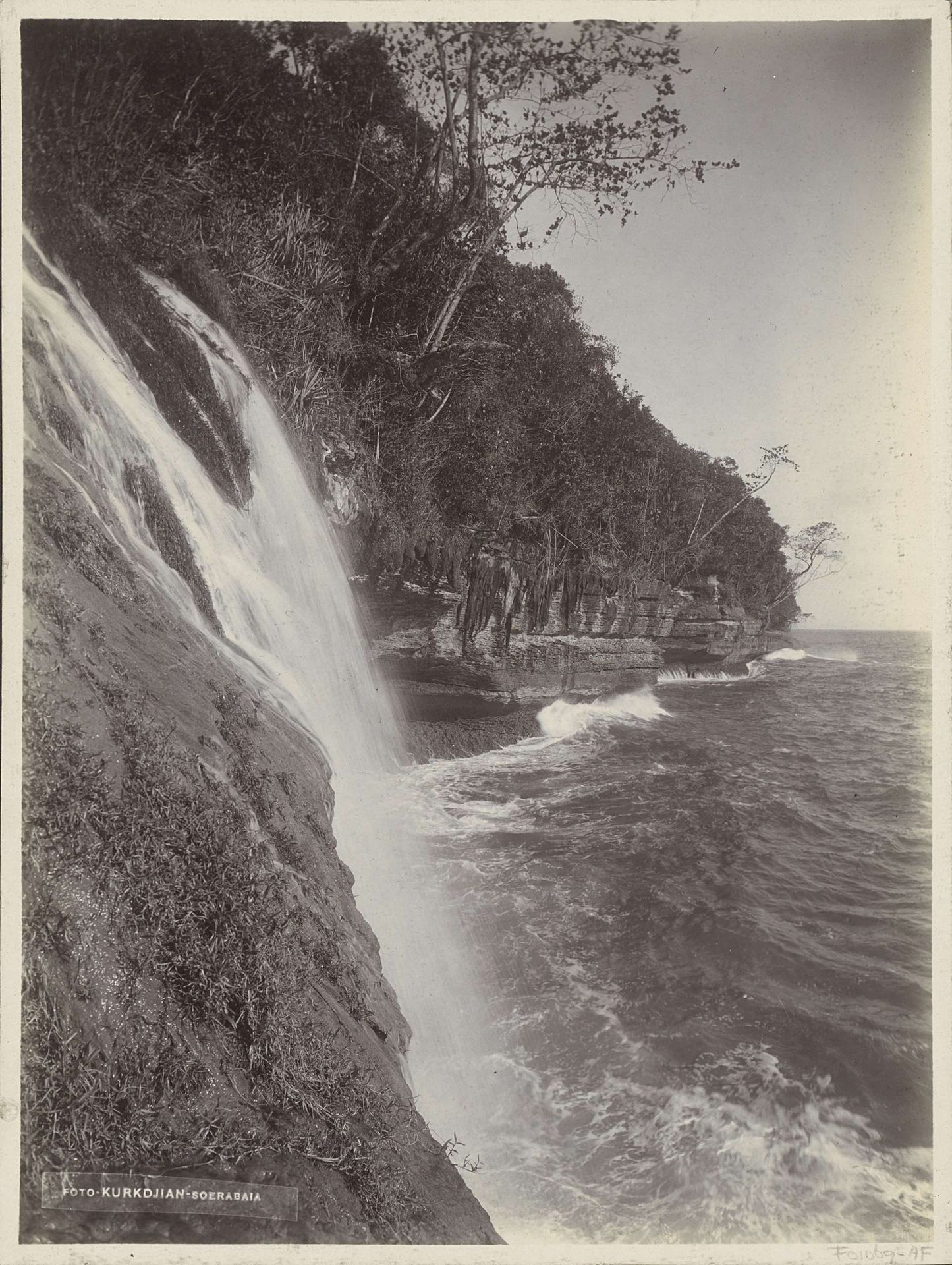 Kust van Nederlands-Indië met waterval uitmondend in zee by Onnes Kurkdjian