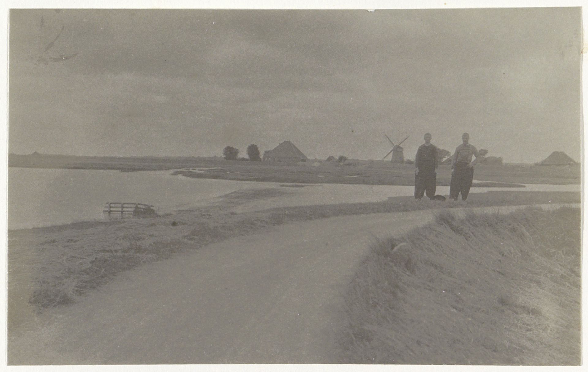 Twee mannen in klederdracht op een dijk bij Volendam by G. Hidderley