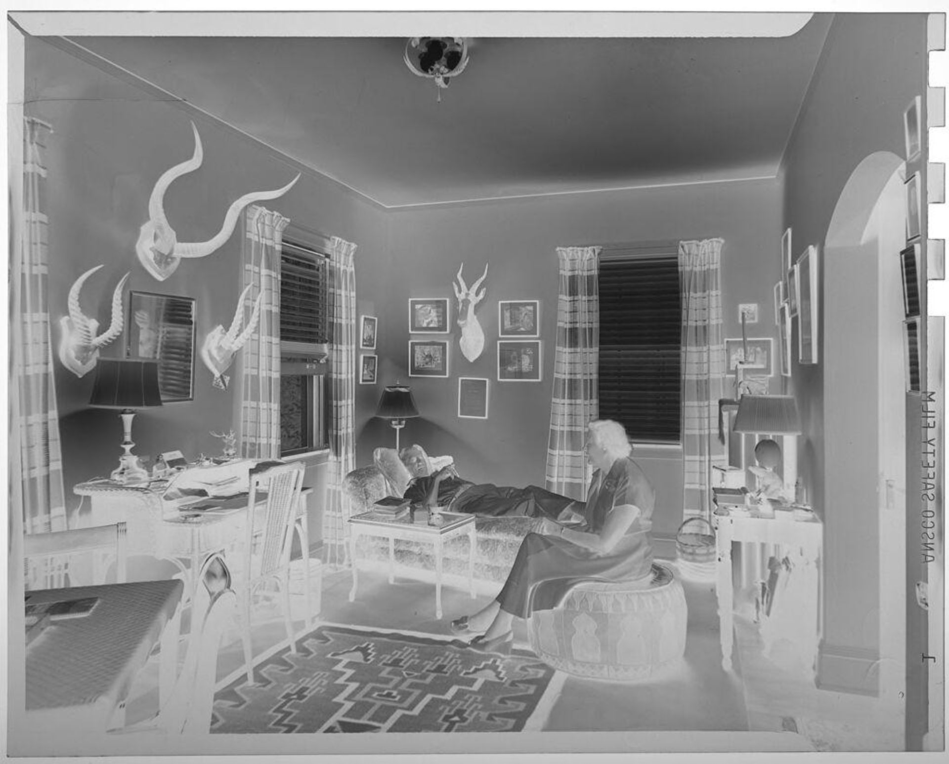 Untitled (couple in room with mounted horns on walls) by Jack Gould