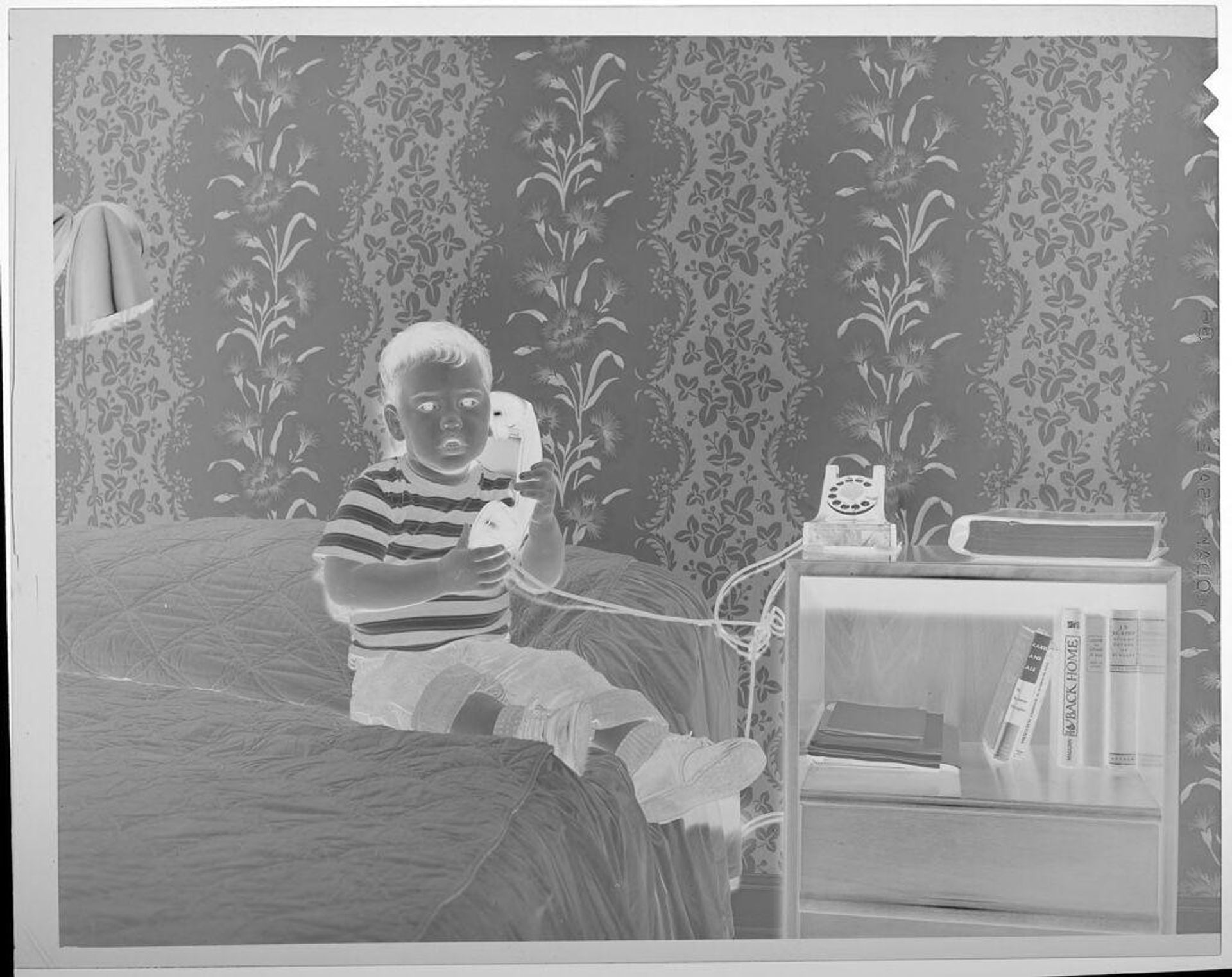 Untitled (boy on bed holding telephone) by Lucian and Mary Brown