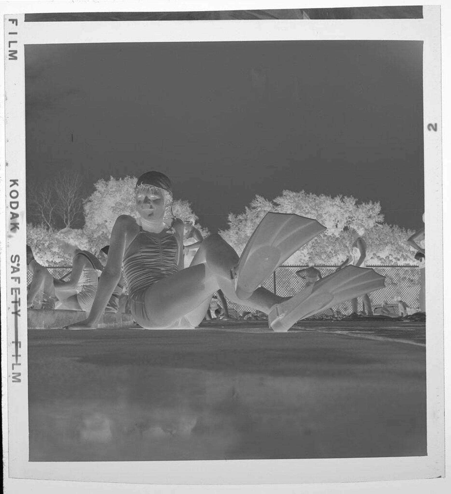 Untitled (girl in bathing cap and flippers on deck by pool) by Jack Gould