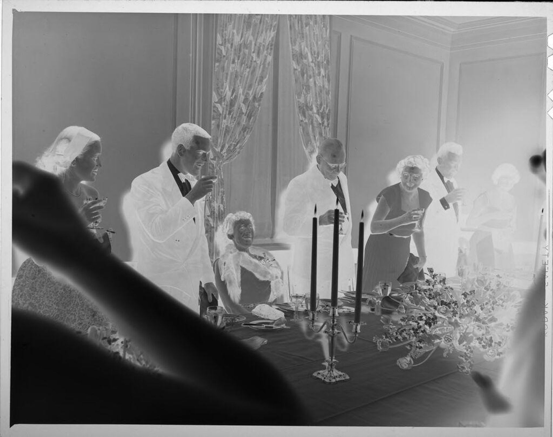 Untitled (people standing around dinner table for toast) by Lucian and Mary Brown