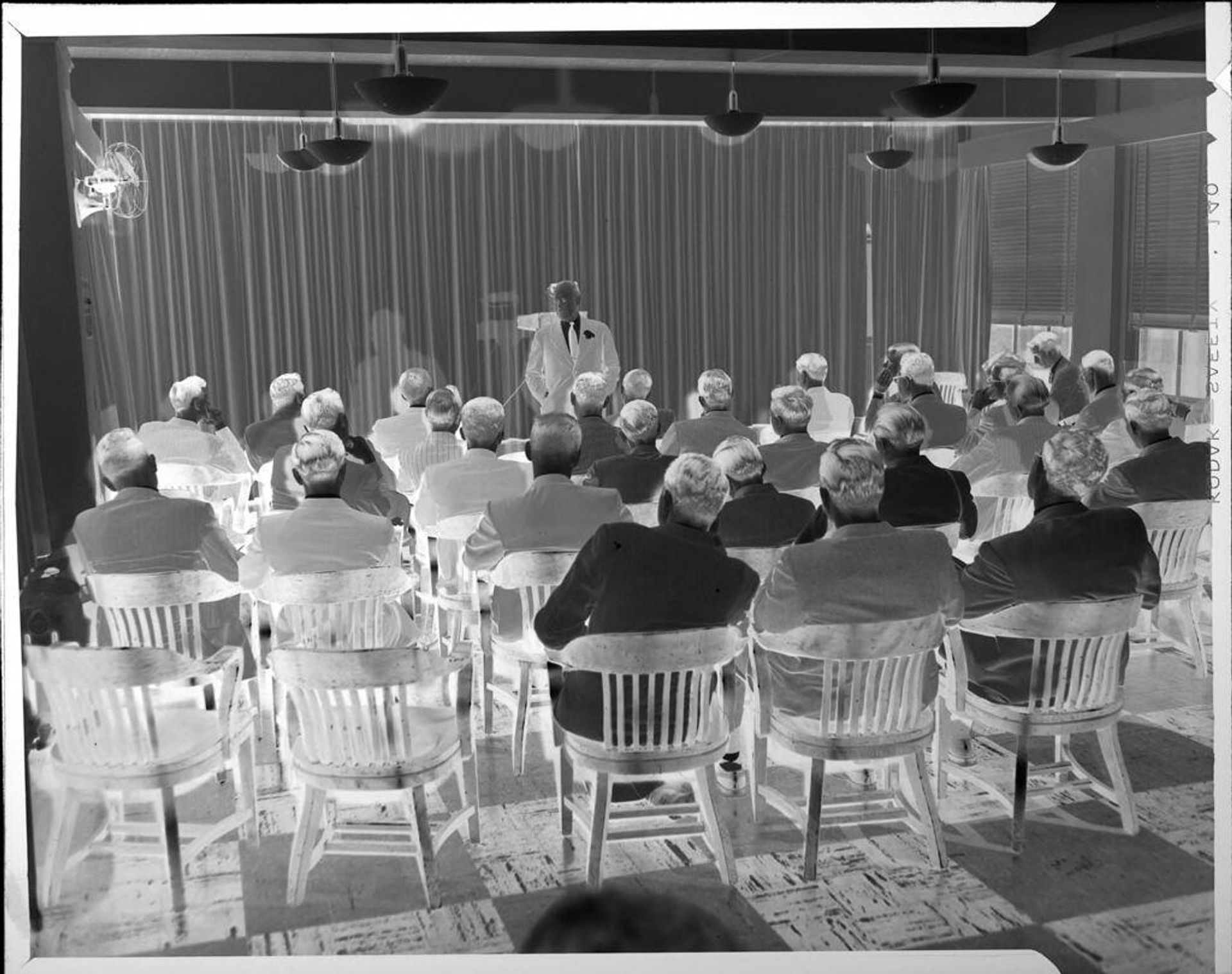 Untitled (man giving presentation to group) by Peter James Studio