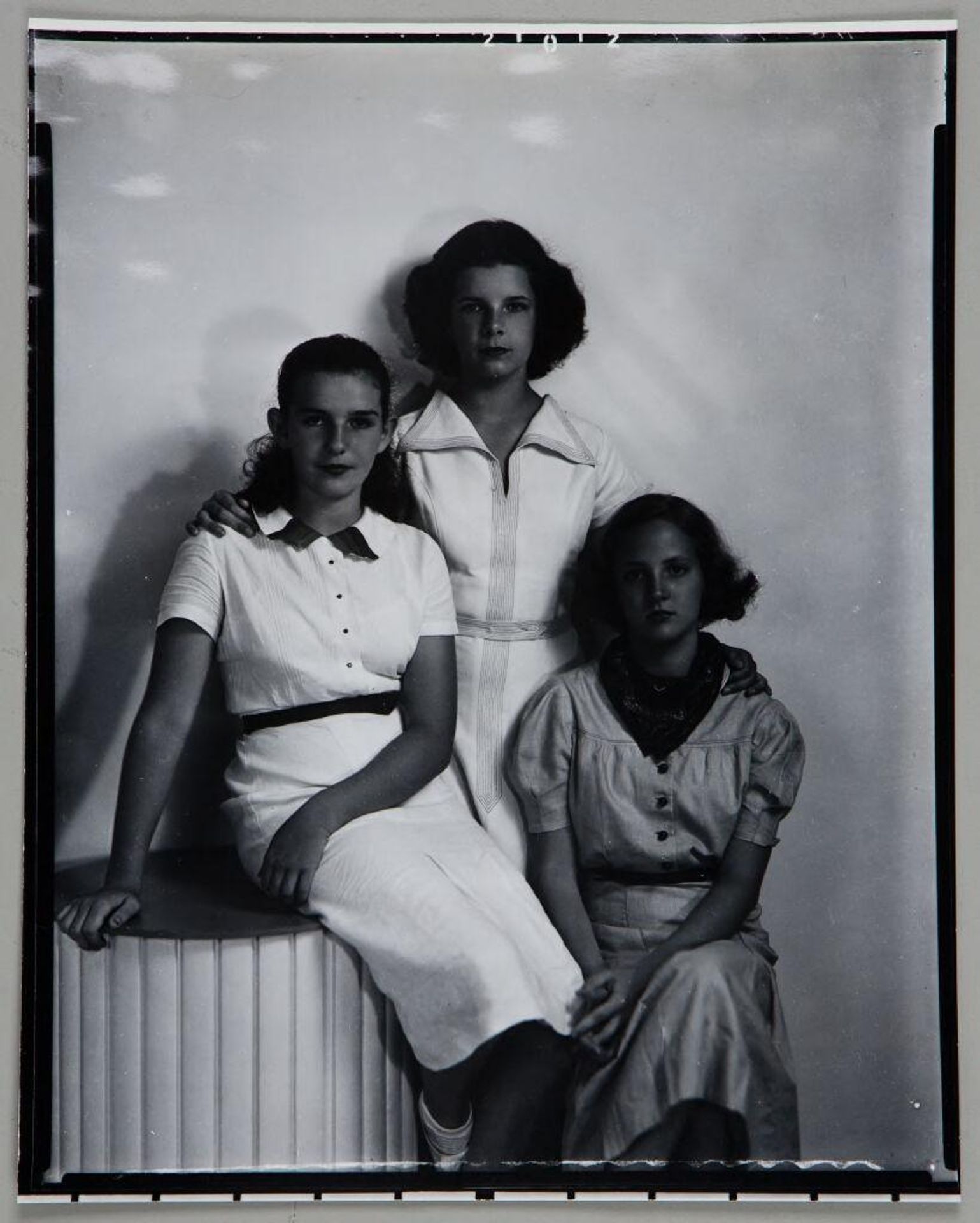 Untitled (three young woman in casual dresses posed with studio prop) by Paul Gittings