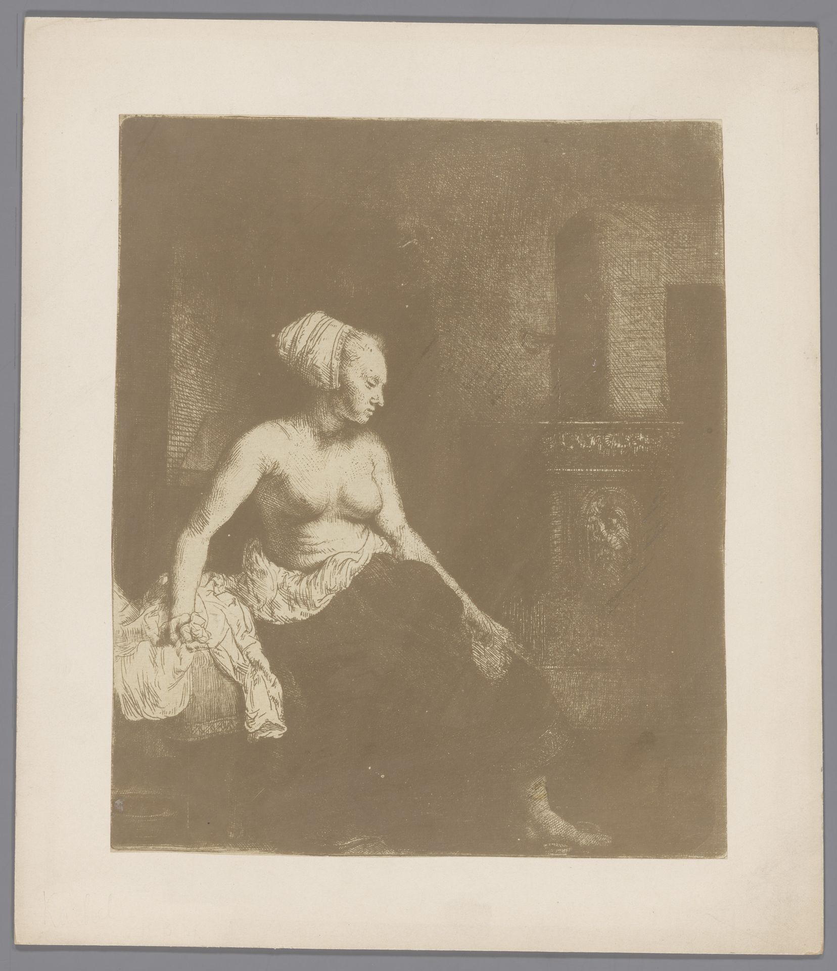 Fotoreproductie van een ets van een vrouw met naakt bovenlichaam bij een kachel door Rembrandt van Rijn by Anonymous