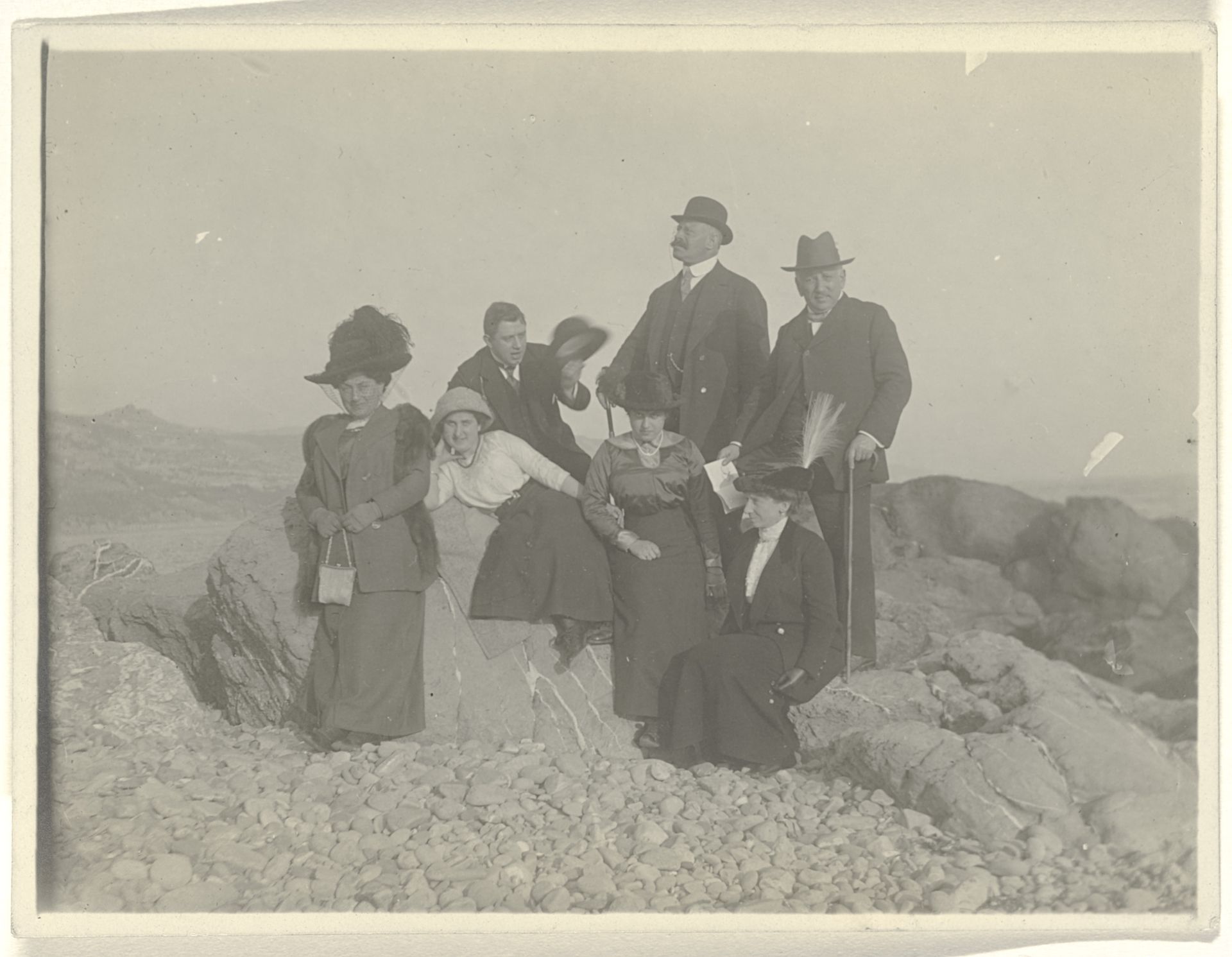 Josefine Moos-Levi, Hermann Moos, Else Wachenheimer-Moos en vier onbekende mensen, zittend op rotsen in een woestijnachtig rotslandschap by Anonymous