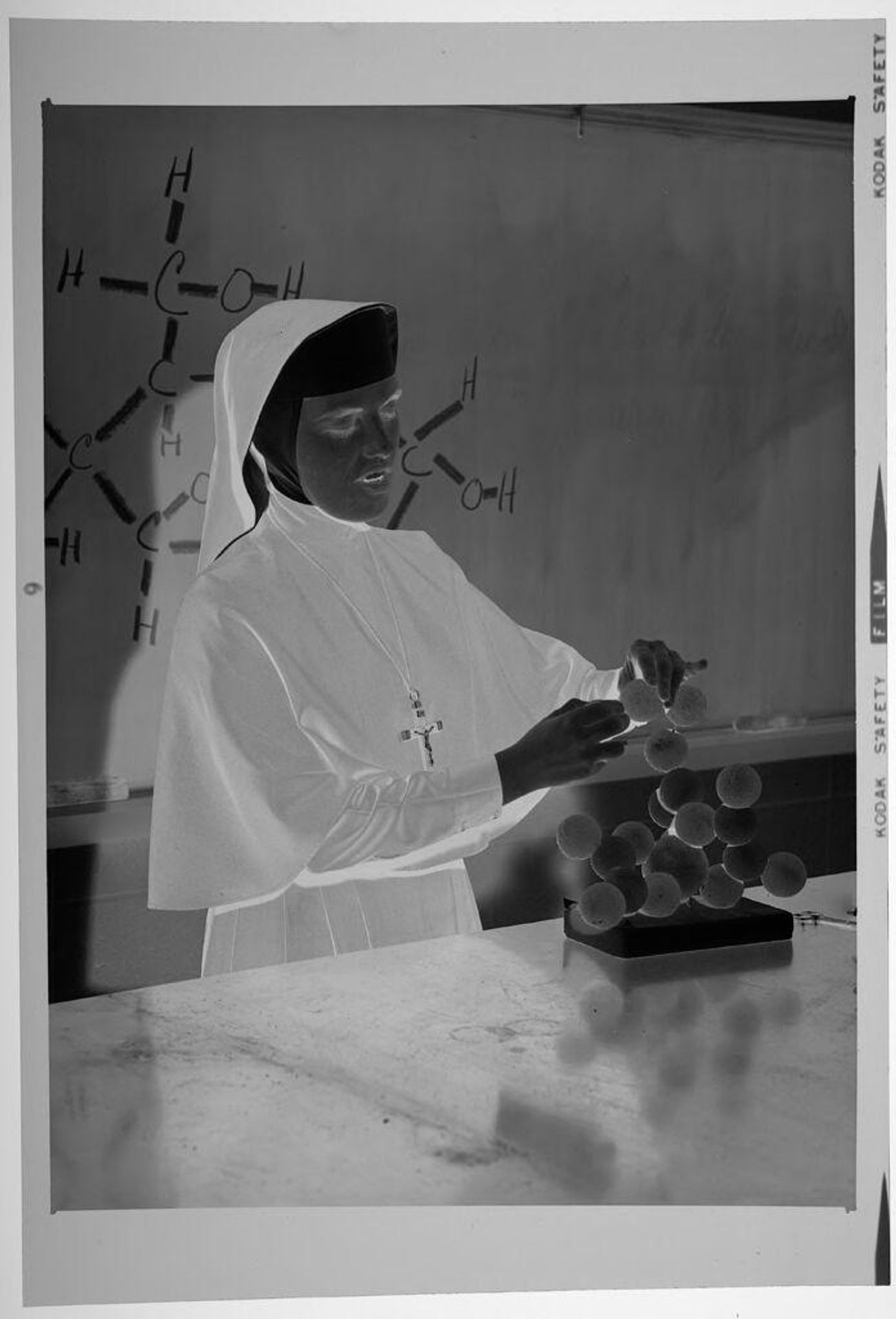 Untitled (nun adjusting molecule structure model in chemistry classroom) by Martin Schweig