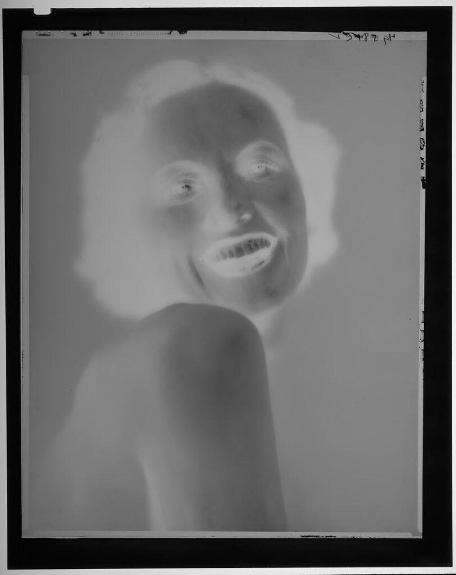 Untitled (portrait of young woman looking over bare shoulder) by Paul Gittings
