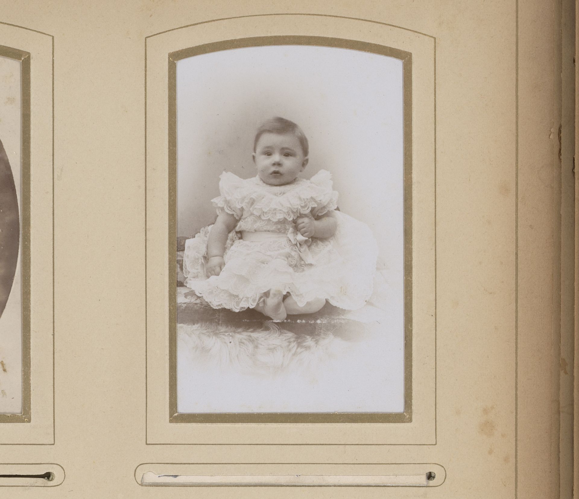 Portret van een zittende baby in witte jurk by E. v.d. Kerkhoff