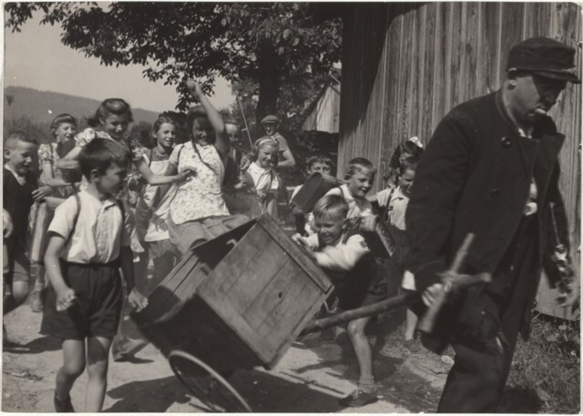 Actor with wheelbarrow followed by children--Filming "Steibruch" by Robert Frank