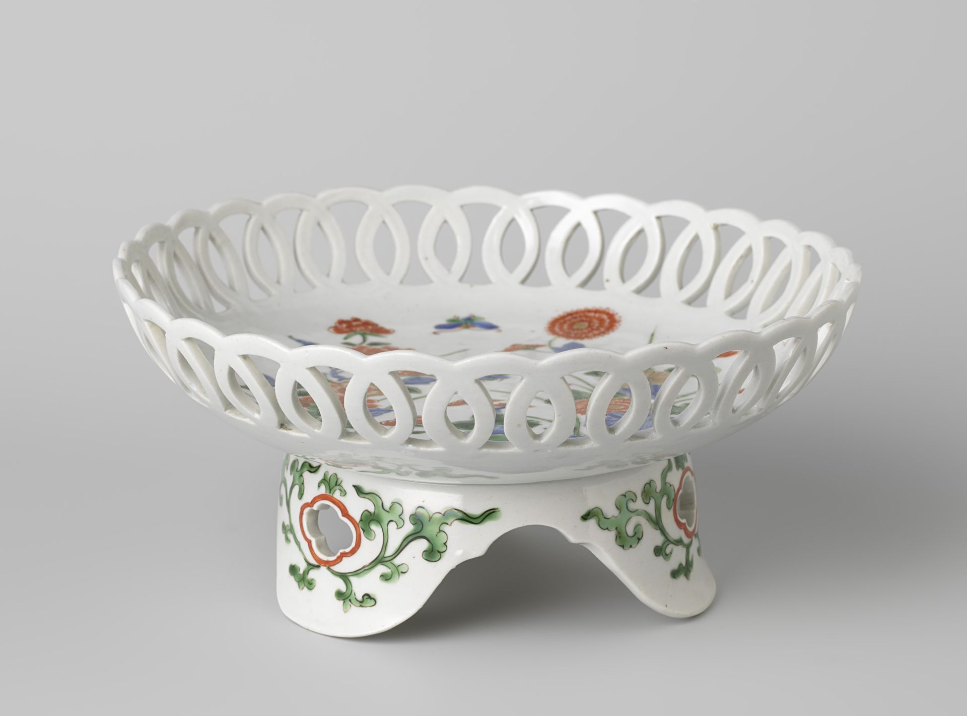 Saucer-dish on tripod with flowering plants near rocks by Anonymous