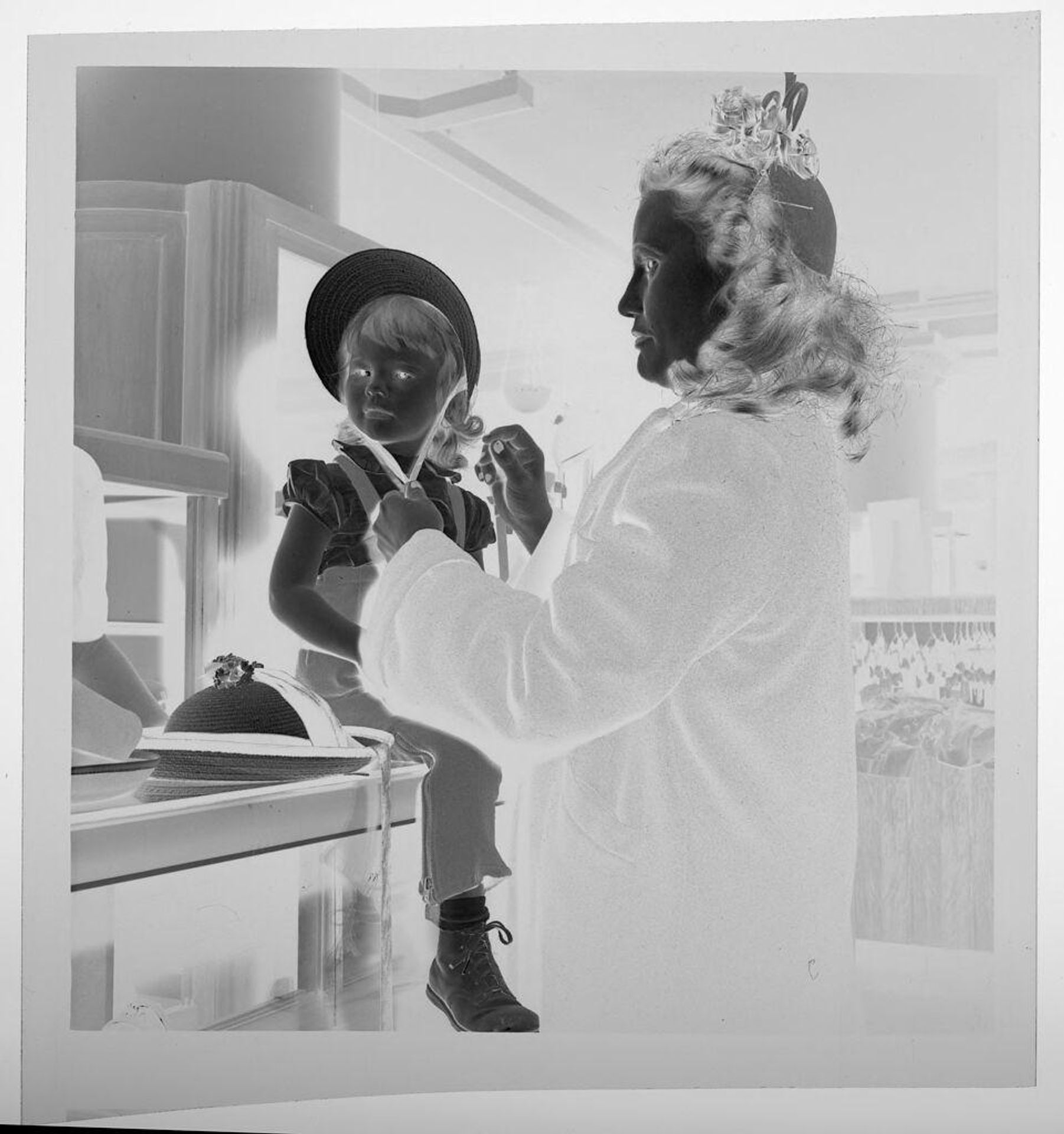 Untitled (woman tying bonnet onto seated child) by Jack Gould