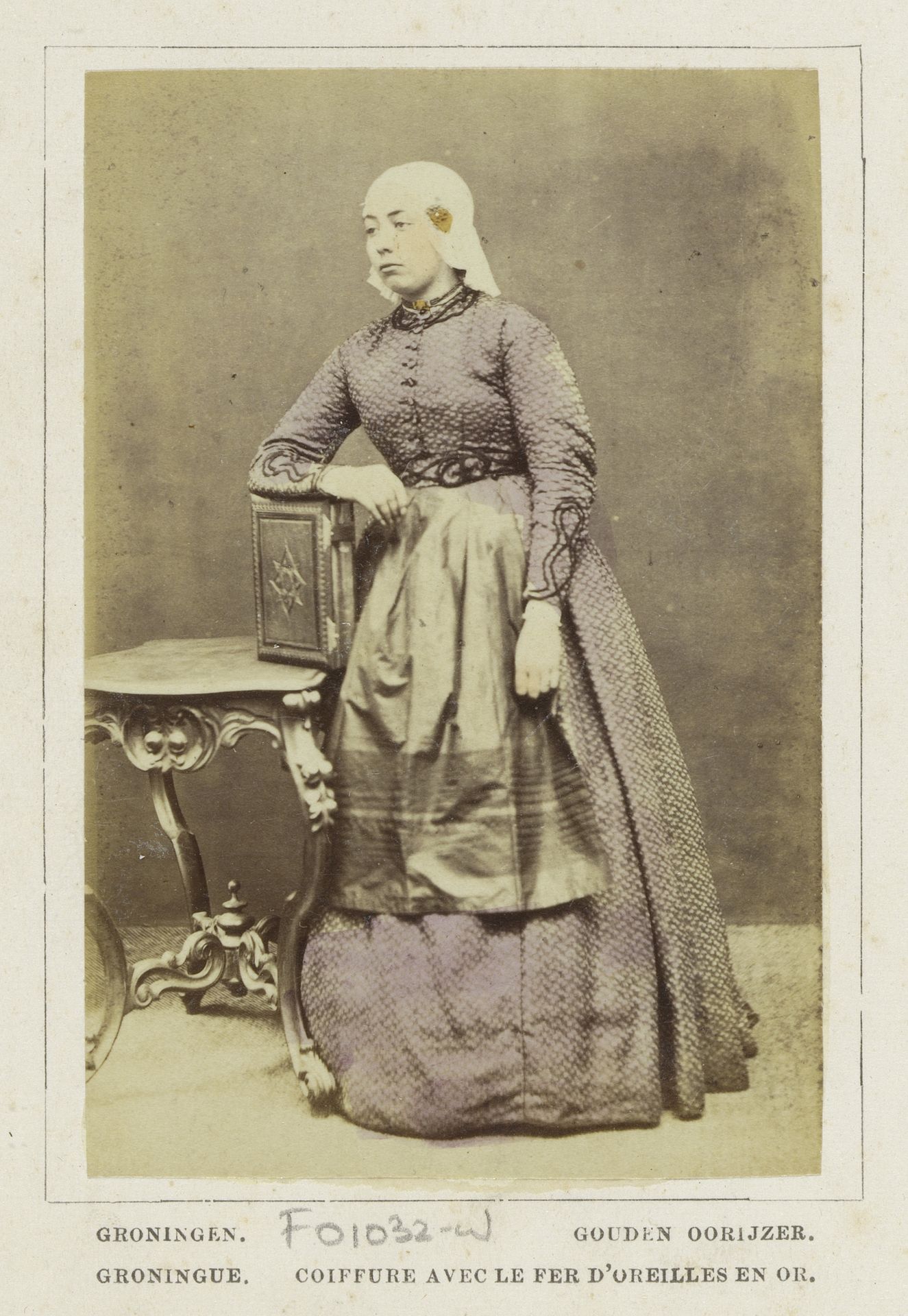 Portret van een onbekende vrouw met fotoalbum of boek in klederdracht van Groningen by Andries Jager