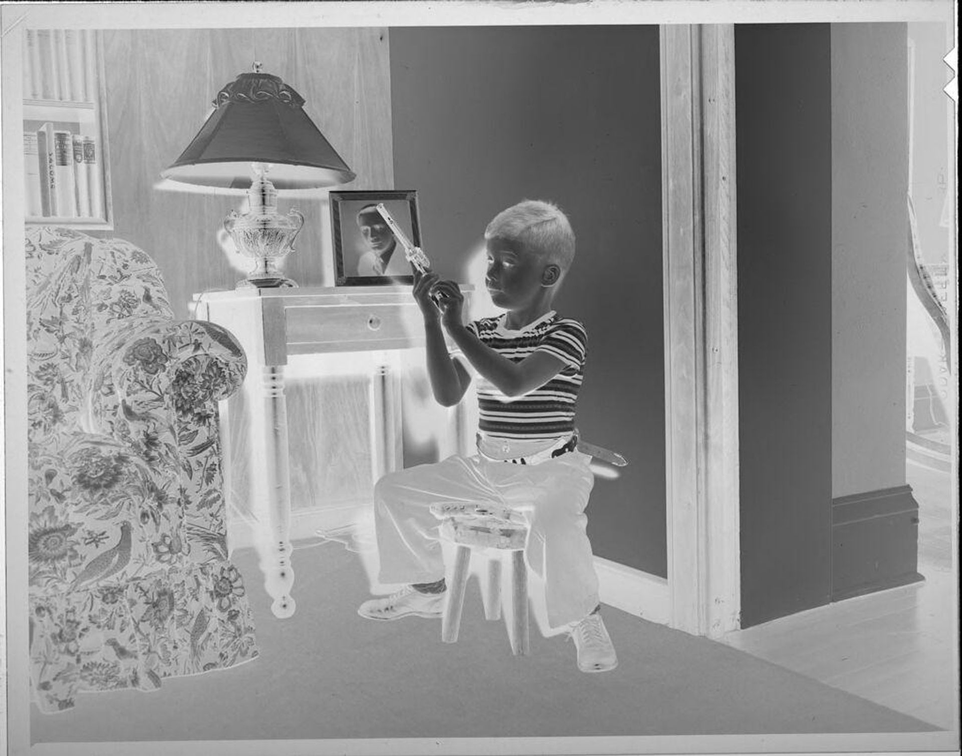 Untitled (boy loading toy gun) by Lucian and Mary Brown