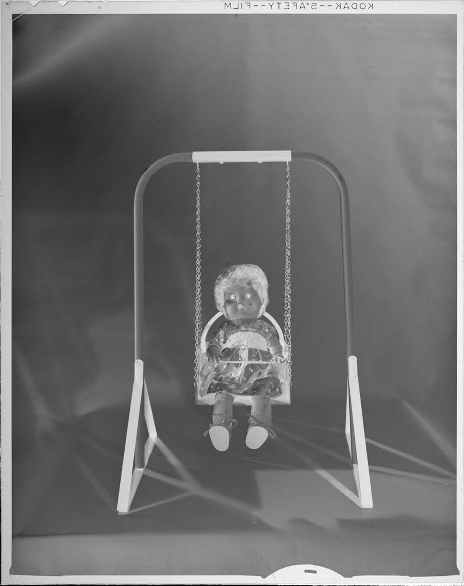 Untitled (doll on swing) by Lucian and Mary Brown